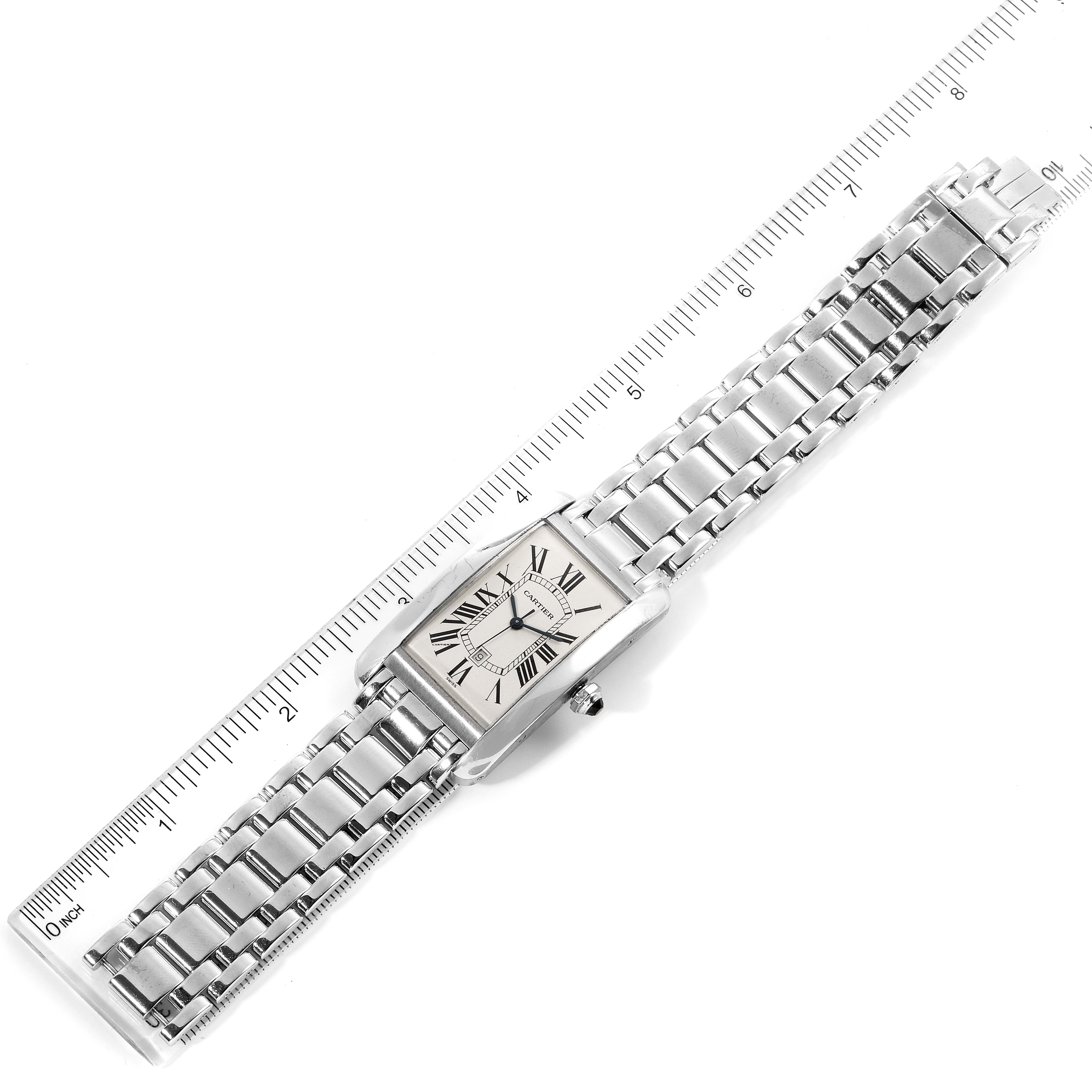 The Cartier Tank Americaine W26032L1 Men's White Gold Silver Dial W26032L1 Men's White Gold Silver Dial watch is shown from a top-down angle, displaying the entire face and band, aligned with a measuring ruler.