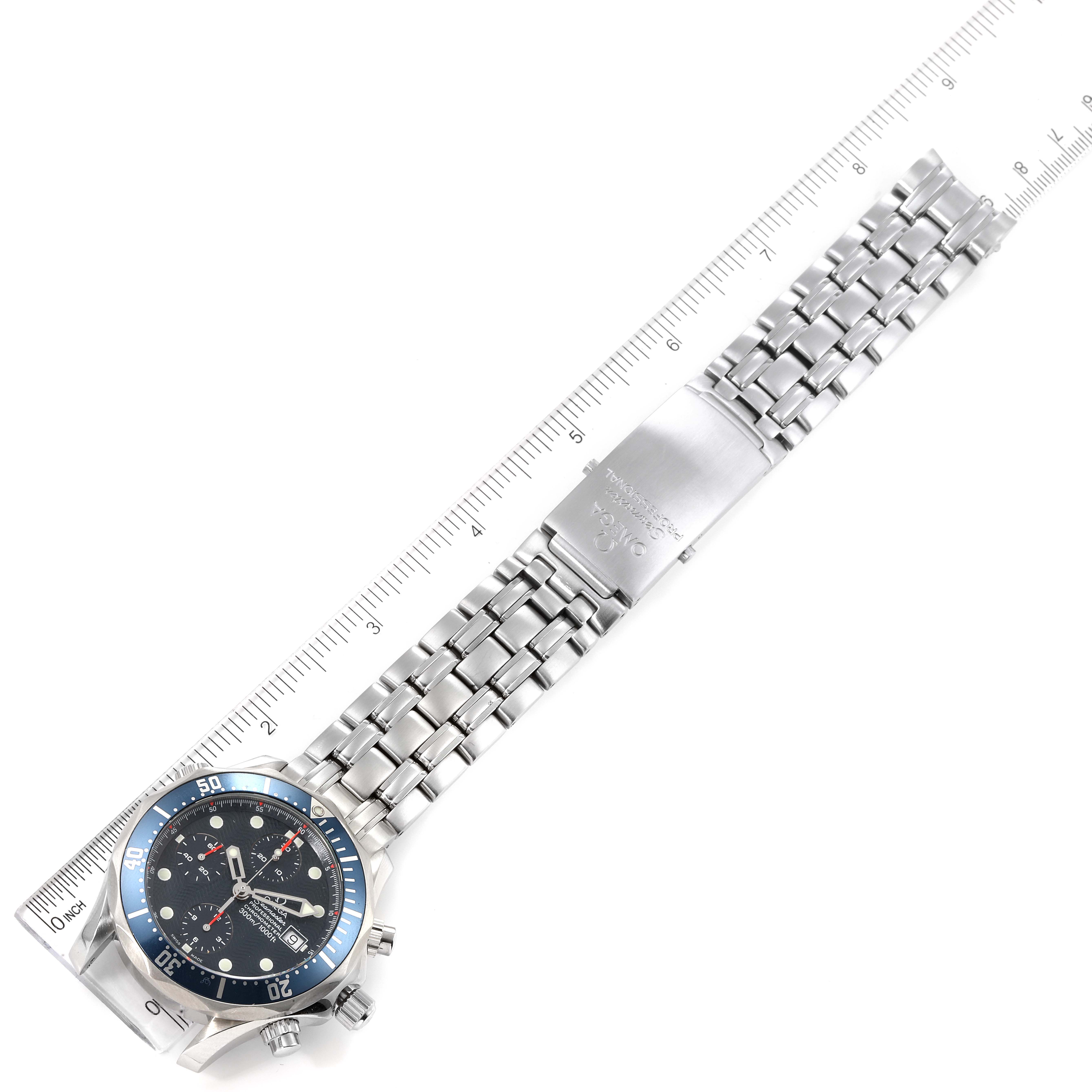 The image shows the Omega Seamaster 2599.80.00 Men's Stainless Steel Blue Dial 2599.80.00 Men's Stainless Steel Blue Dial watch laid flat with its metal bracelet extended, alongside a ruler for measurement.