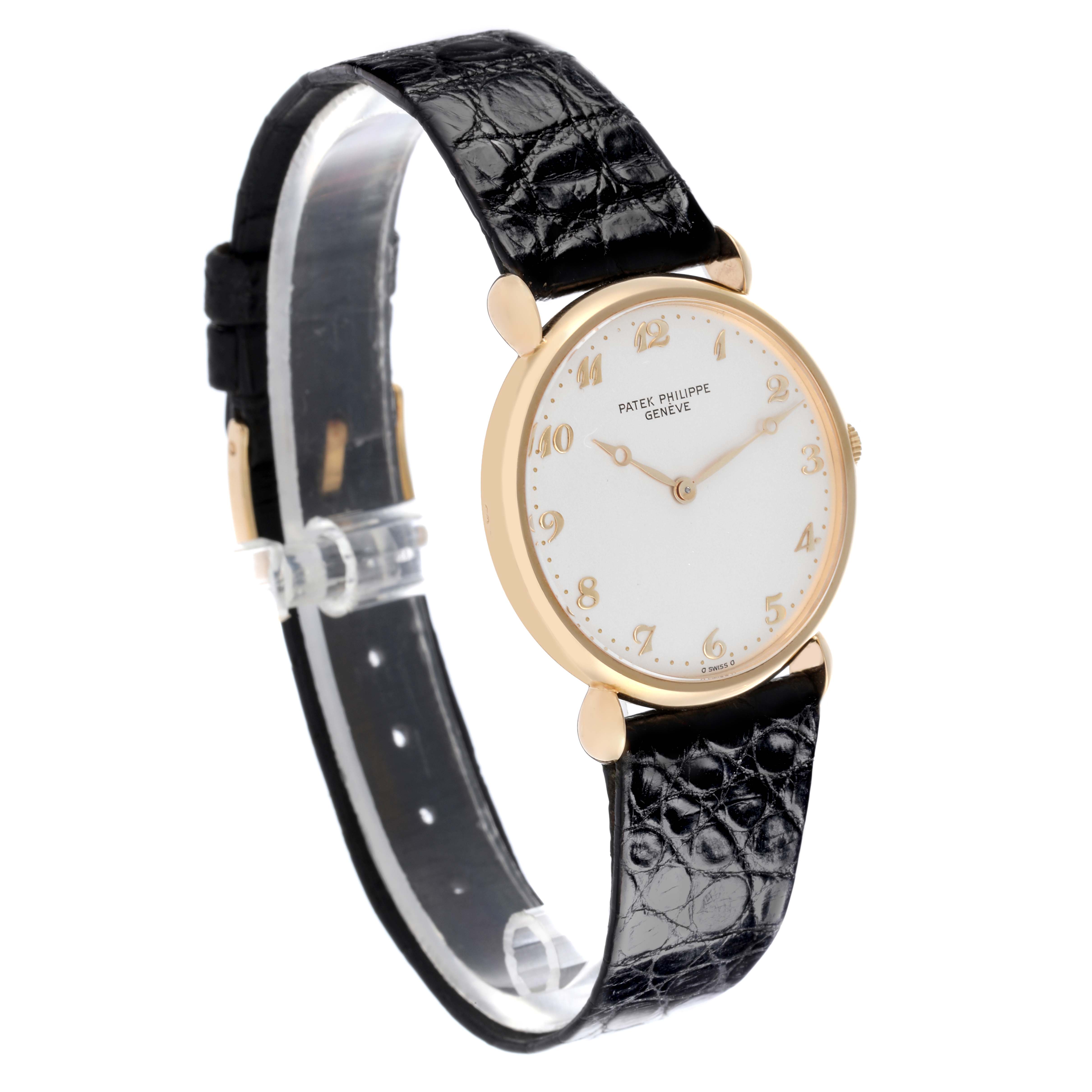 The Patek Philippe Calatrava Men's Yellow Gold Silver Dial Men's Yellow Gold Silver Dial watch is shown at an angled side view, highlighting the face, case, and leather strap.