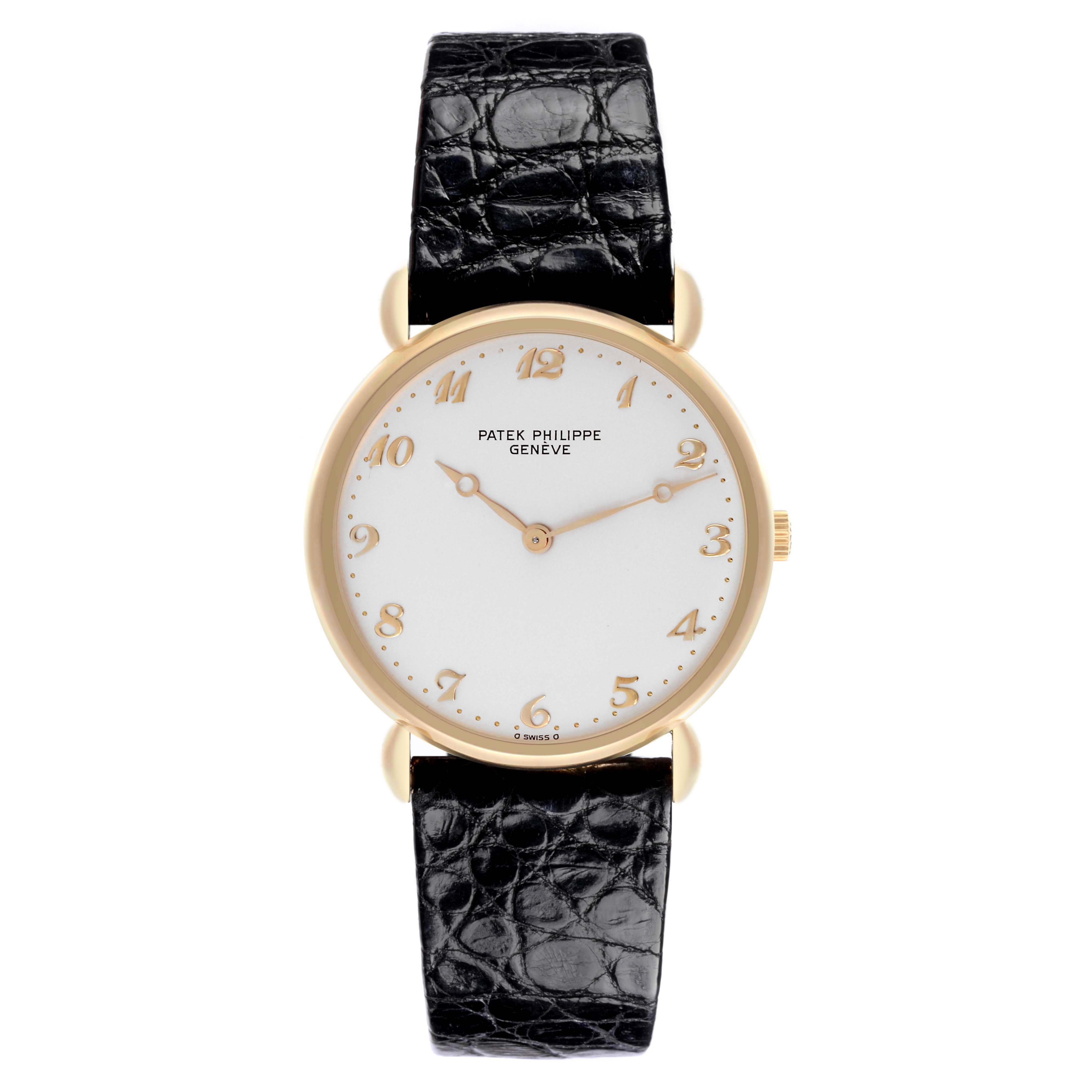 The Patek Philippe Calatrava Men's Yellow Gold Silver Dial Men's Yellow Gold Silver Dial watch is shown from the front, displaying its face, gold numerals, and black leather strap.