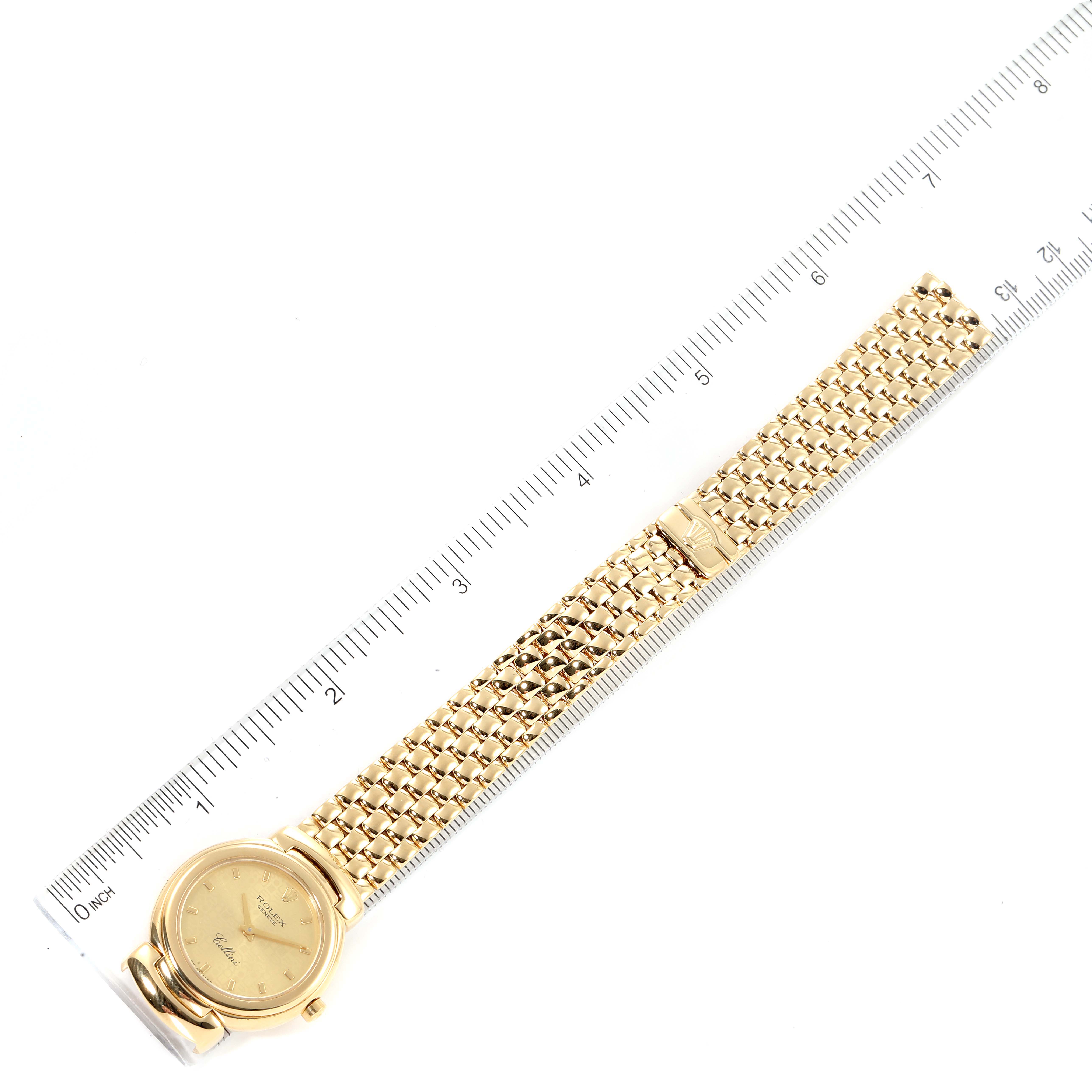 The Rolex Cellini 6621 Women's Yellow Gold Champagne Dial 6621 Women's Yellow Gold Champagne Dial watch is shown from a top-down angle, displaying its face, band, and clasp alongside a ruler for scale.