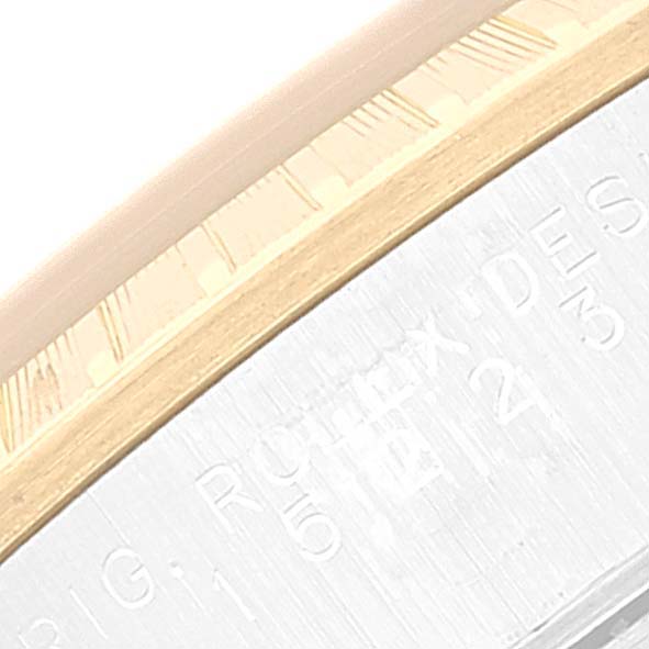 The image shows a close-up of the bezel and part of the engraved case of a Rolex Date 15223 Men
s Steel and Gold (two tone) Champagne Dial 15223 Men
s Steel and Gold (two tone) Champagne Dial watch.