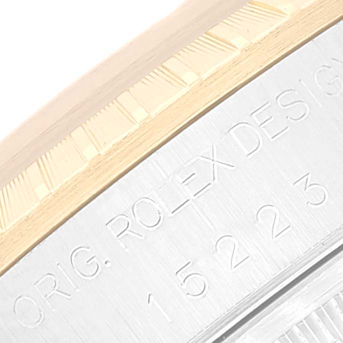 The image shows a close-up of the bezel and case side of a Rolex Date 15223 Men
s Steel and Gold (two tone) Champagne Dial 15223 Men
s Steel and Gold (two tone) Champagne Dial model watch, highlighting the engraved serial number and "Orig. Rolex Design" text.