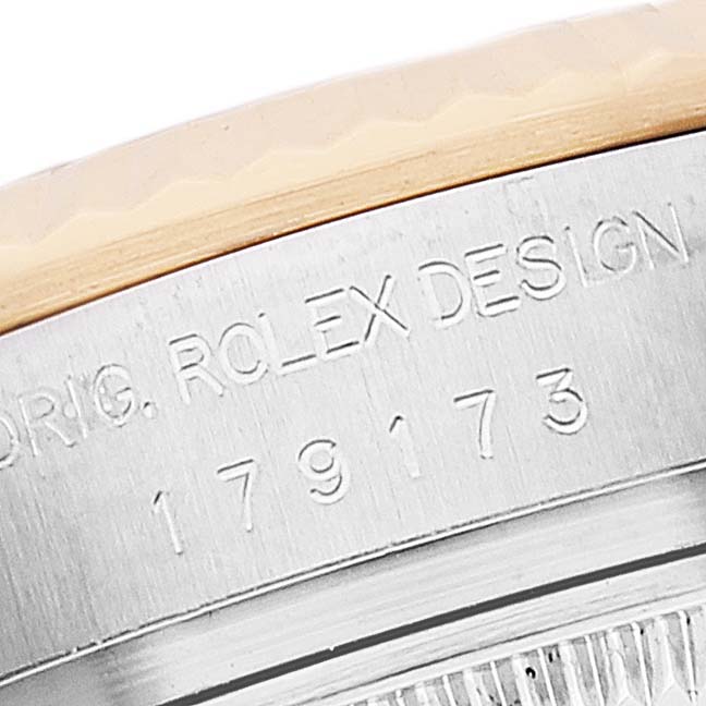 The image shows a close-up angle of the bezel and case edge of the Rolex Datejust 179173 Women's Steel and Gold (two tone) Silver Dial 179173 Women's Steel and Gold (two tone) Silver Dial model, revealing the model number and "Rolex Design."