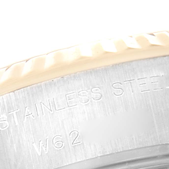 This close-up image of the Rolex Datejust 69173 Women's Steel and Gold (two tone) Champagne Dial 69173 Women's Steel and Gold (two tone) Champagne Dial shows part of the watch's stainless steel case with engraved text.