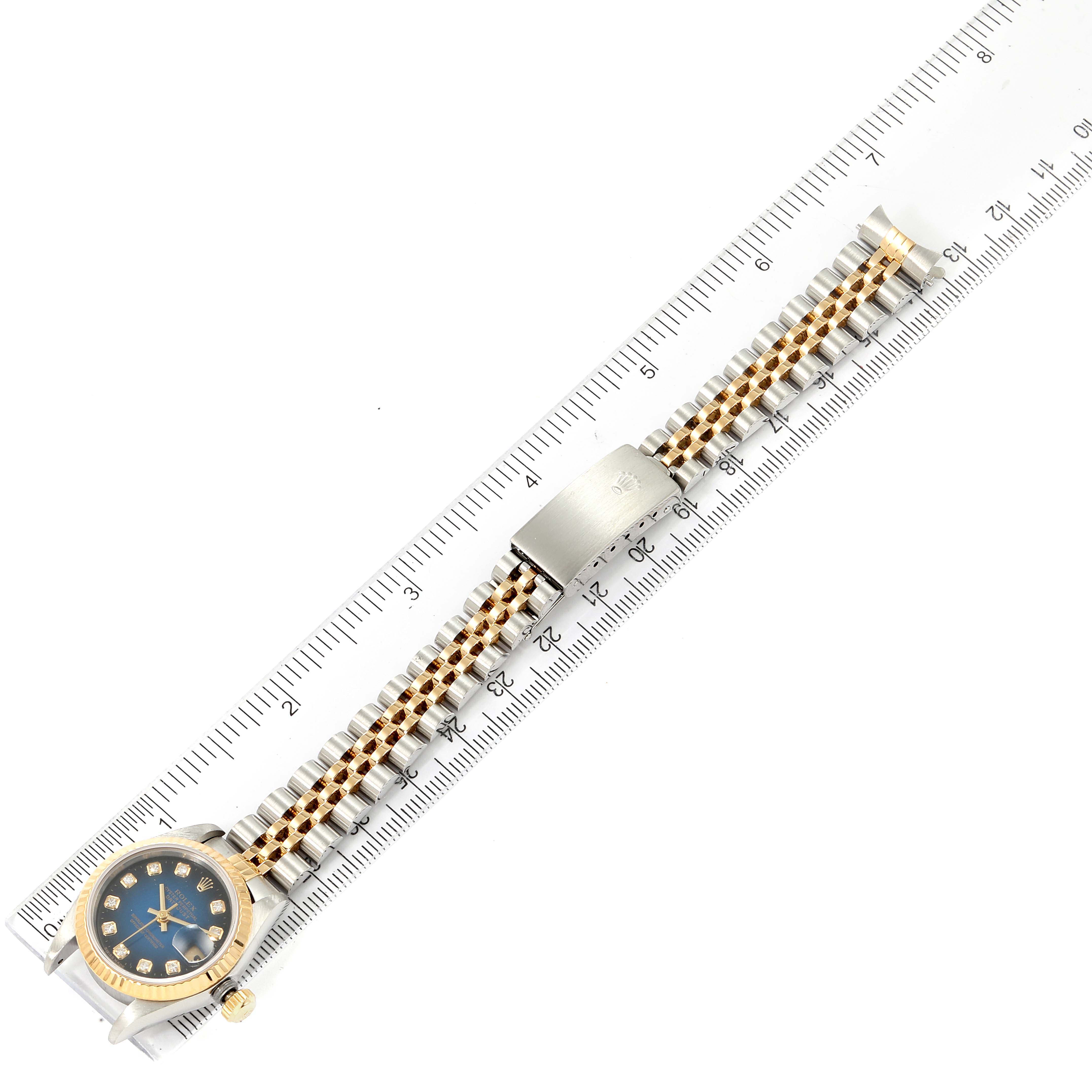 The image shows a top view of a Rolex Datejust 69173 Women's Steel and Gold (two tone) Blue Dial 69173 Women's Steel and Gold (two tone) Blue Dial watch, highlighting its dial, bracelet, and clasp laid on a ruler.
