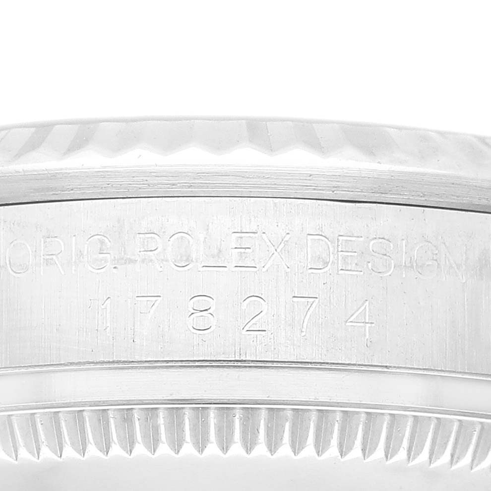 This image shows a close-up of the side engraving and bezel teeth of a Mid-Size Rolex watch.