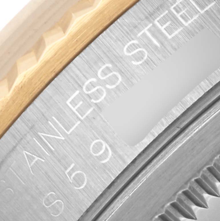 The image shows a close-up of the Rolex Datejust 16233 Men's Steel and Gold (two tone) Black Dial 16233 Men's Steel and Gold (two tone) Black Dial’s stainless steel and gold fluted bezel.