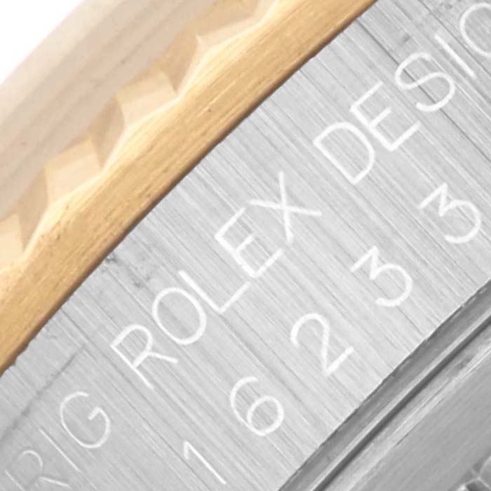 The close-up image shows the side engraving and fluted bezel of a Rolex Datejust 16233 Men's Steel and Gold (two tone) Black Dial 16233 Men's Steel and Gold (two tone) Black Dial watch.