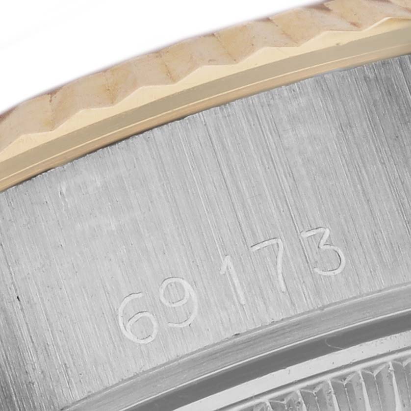 The image shows a close-up of the case side and bezel of a Rolex Date 69173 Women
s Steel and Gold (two tone) White Dial 69173 Women
s Steel and Gold (two tone) White Dial model, with engraved numbers visible.