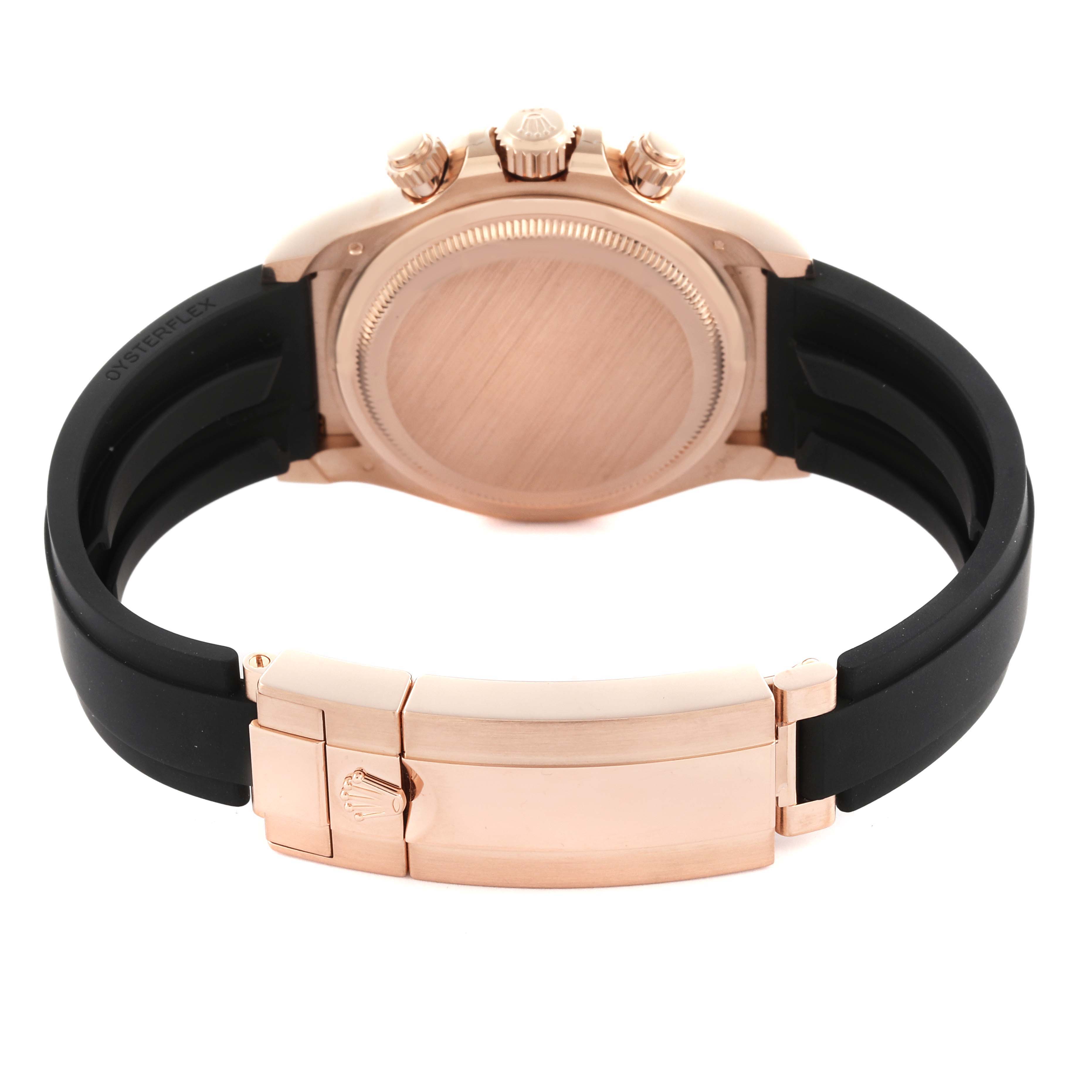 The image shows the back and clasp of a Rolex Daytona 126515 Men's Rose Gold Black Dial 126515 Men's Rose Gold Black Dial watch, featuring a rose gold case and black Oysterflex strap.