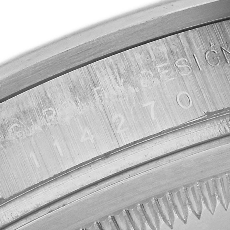 The image shows a close-up side view of the Rolex Explorer 114270 Men
s Stainless Steel Black Dial 114270 Men
s Stainless Steel Black Dial
s engraved rim, highlighting the serial number.