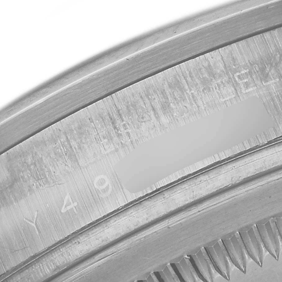 The image shows a close-up of the engraved edge of a Rolex Explorer 114270 Men
s Stainless Steel Black Dial 114270 Men
s Stainless Steel Black Dial model
s case back.