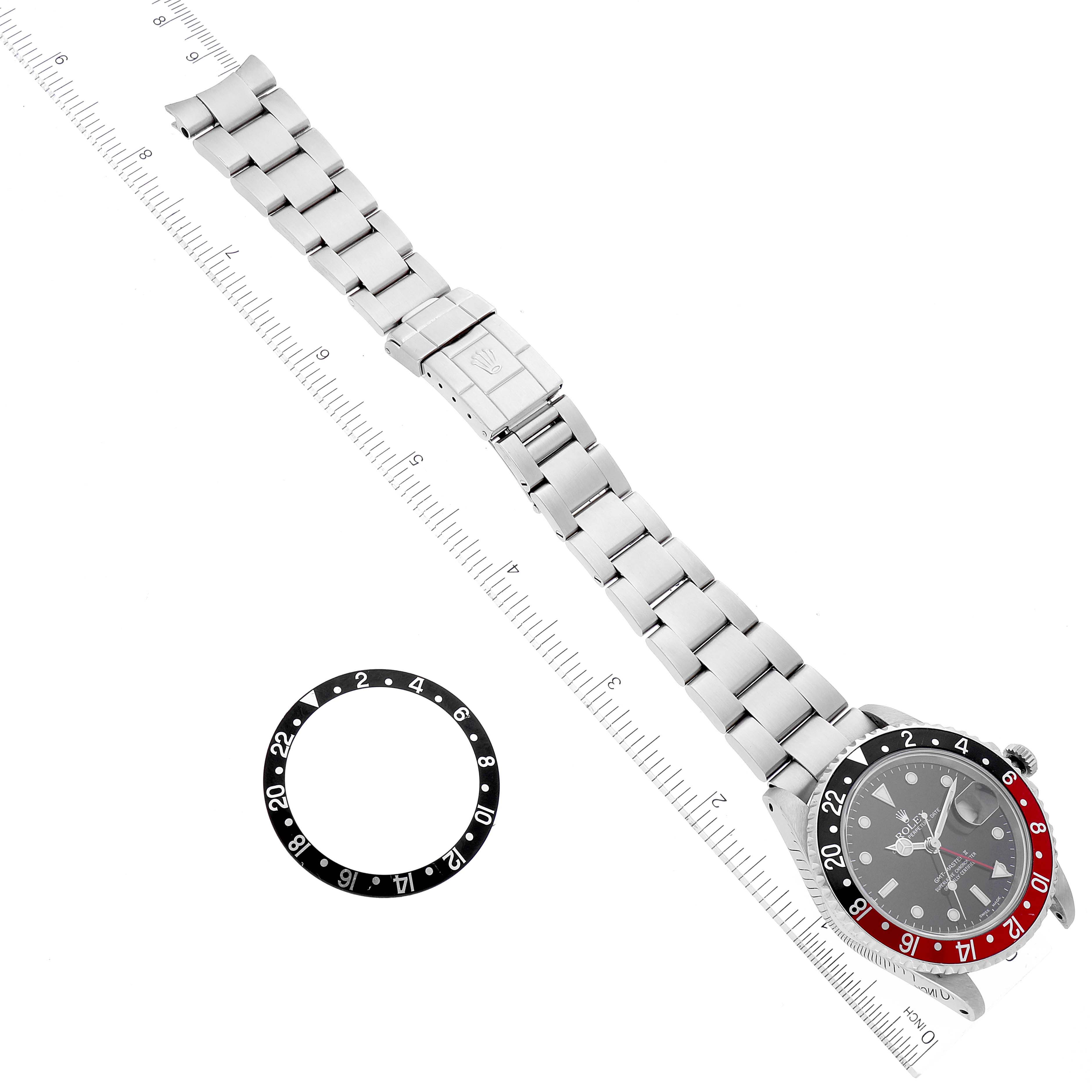 The image shows a Rolex GMT-Master 16710 Men
s Stainless Steel Black Dial 16710 Men
s Stainless Steel Black Dial watch laid flat, with a separated black and white bezel ring beside it.