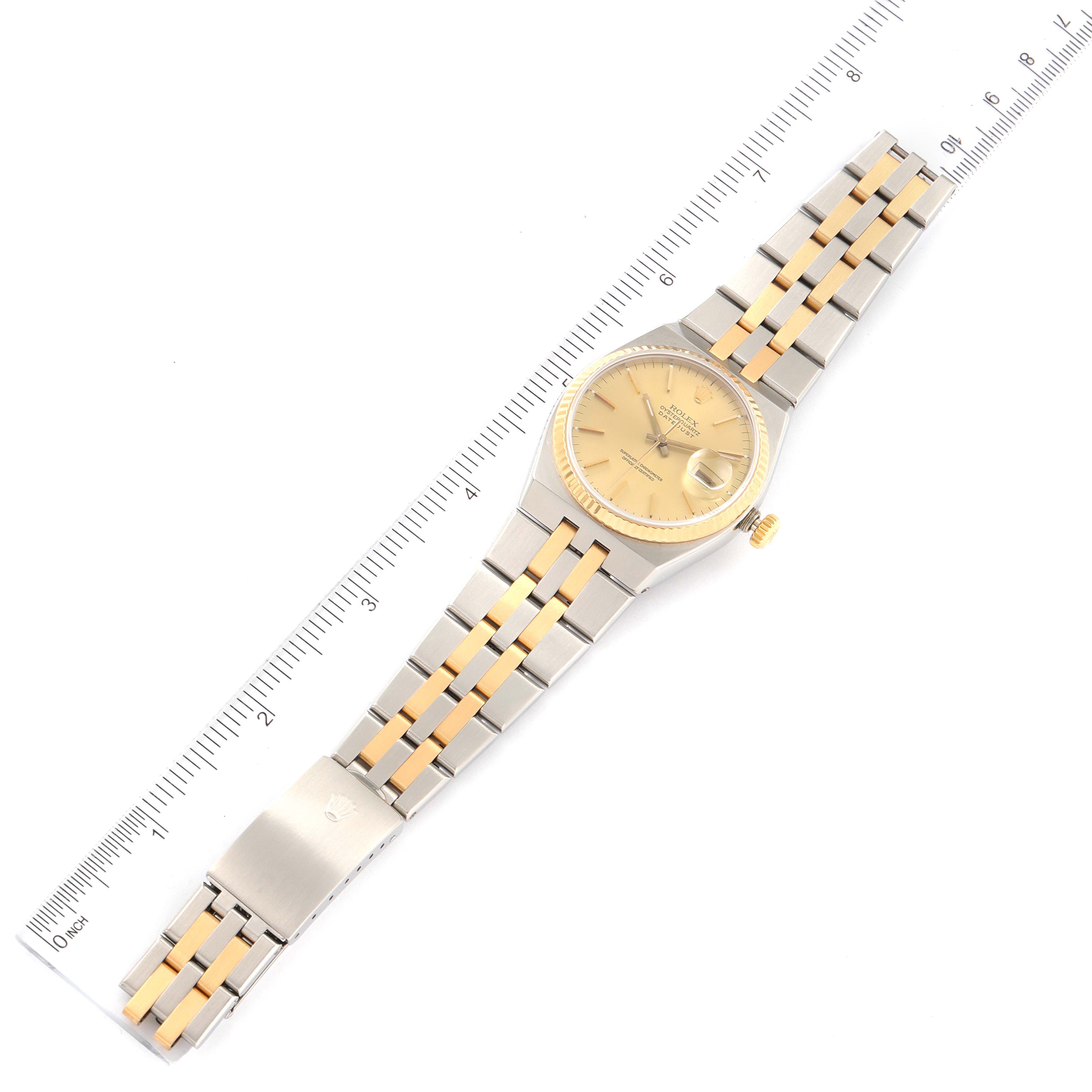 The image shows a Rolex Oysterquartz 17013 Men's Steel and Gold (two tone) Champagne Dial 17013 Men's Steel and Gold (two tone) Champagne Dial watch in a flat position with a full view of the dial, case, bracelet, and clasp next to a ruler.