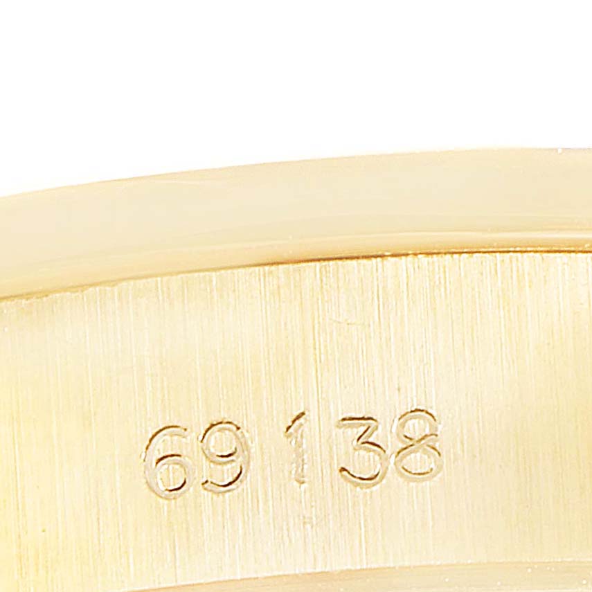 This close-up image shows a portion of the band on a Rolex President 69138 Women
s Yellow Gold Champagne Dial 69138 Women
s Yellow Gold Champagne Dial model watch with partial serial number engraving.