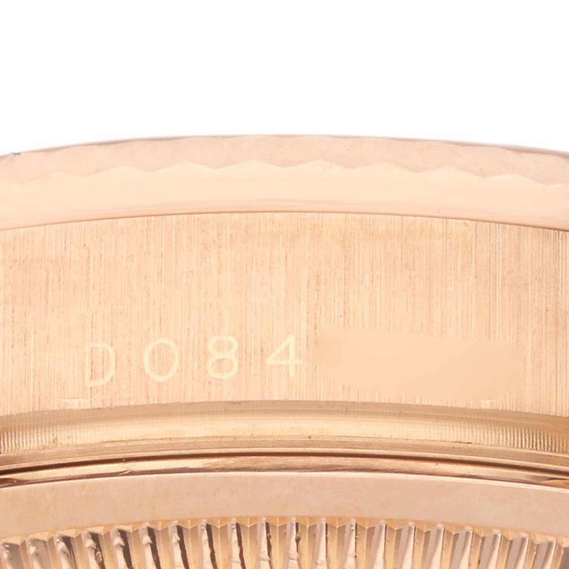 The image shows a close-up of the edge and serial number engraving on a Rolex President 118235 Men's Rose Gold Pink Dial 118235 Men's Rose Gold Pink Dial model.