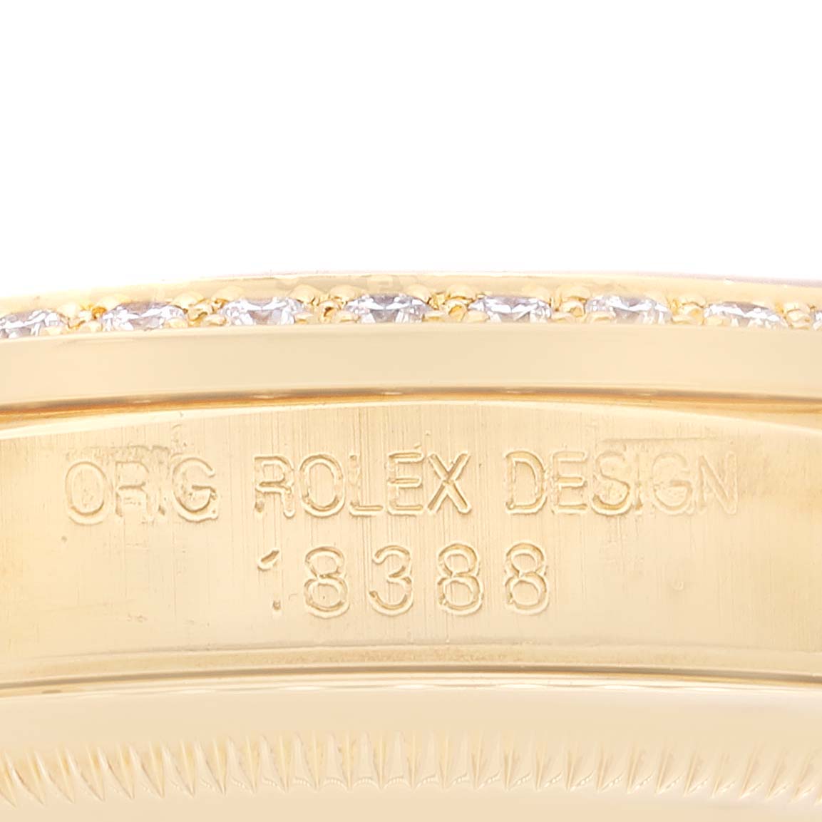 The image shows a close-up of the engraved side of a Rolex President 18388 Men
s Yellow Gold Champagne Dial 18388 Men
s Yellow Gold Champagne Dial model watch, featuring its design number and diamond accents.