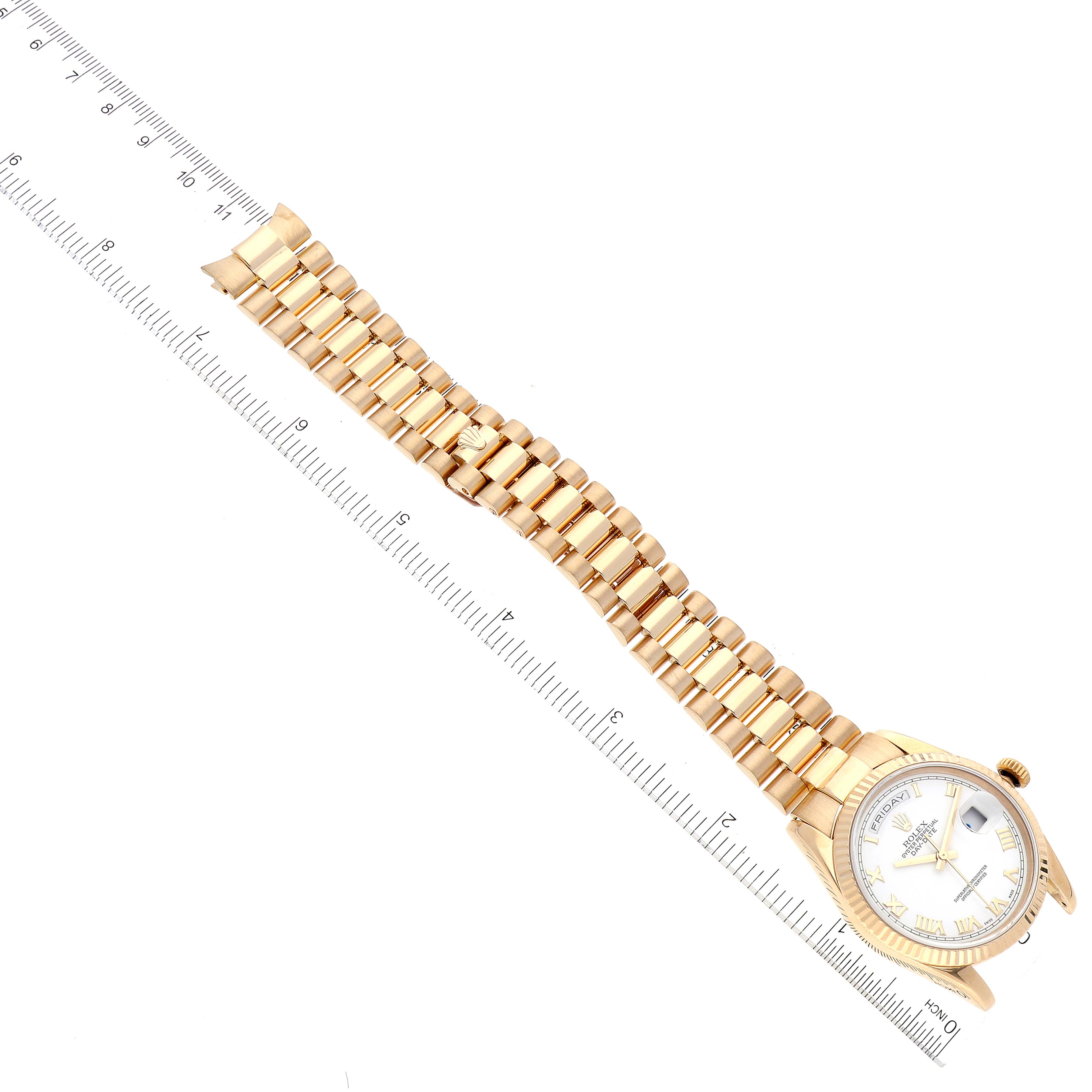 The image shows a top-down view of a Rolex President 118238 Men
s Yellow Gold White Dial 118238 Men
s Yellow Gold White Dial model watch, including the face and full bracelet next to a ruler.