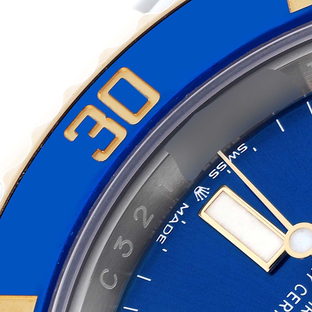 The close-up image shows the Rolex Submariner 126613LB Men's Steel and Gold (two tone) Blue Dial 126613LB Men's Steel and Gold (two tone) Blue Dial's blue bezel with gold numbering and part of the dial with hands.