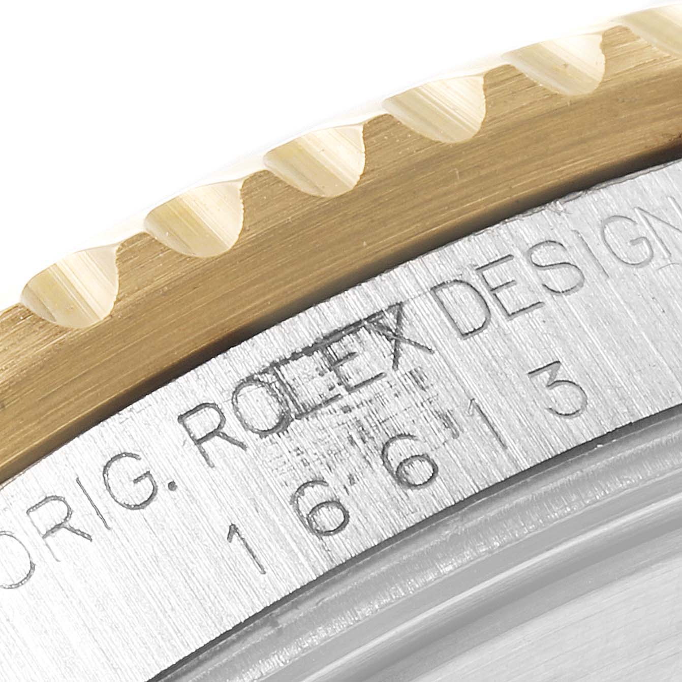 The close-up of the Rolex Submariner 16613 Men
s Steel and Gold (two tone) Blue Dial 16613 Men
s Steel and Gold (two tone) Blue Dial model shows a portion of the bezel and the engraved serial number and branding on the watch
s side.