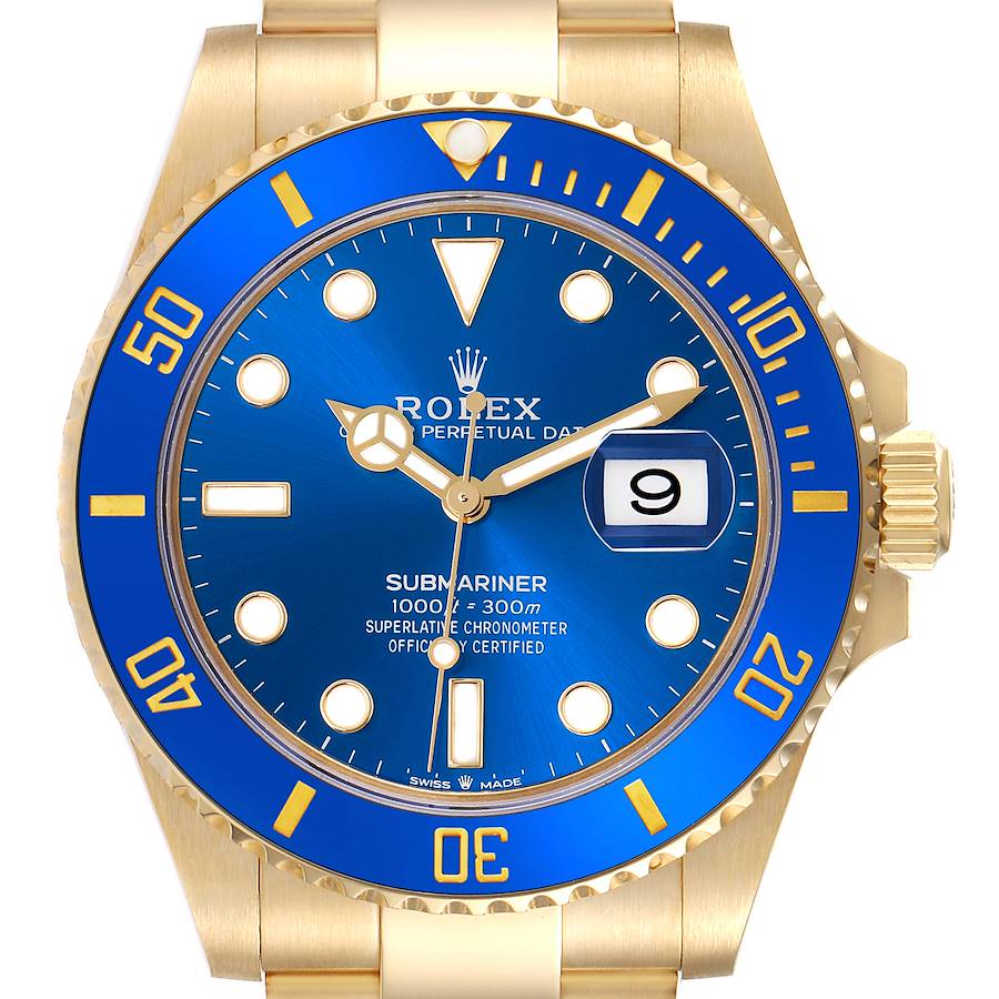 The image shows a frontal view of a Rolex Submariner watch, highlighting the blue dial, bezel, and gold bracelet.