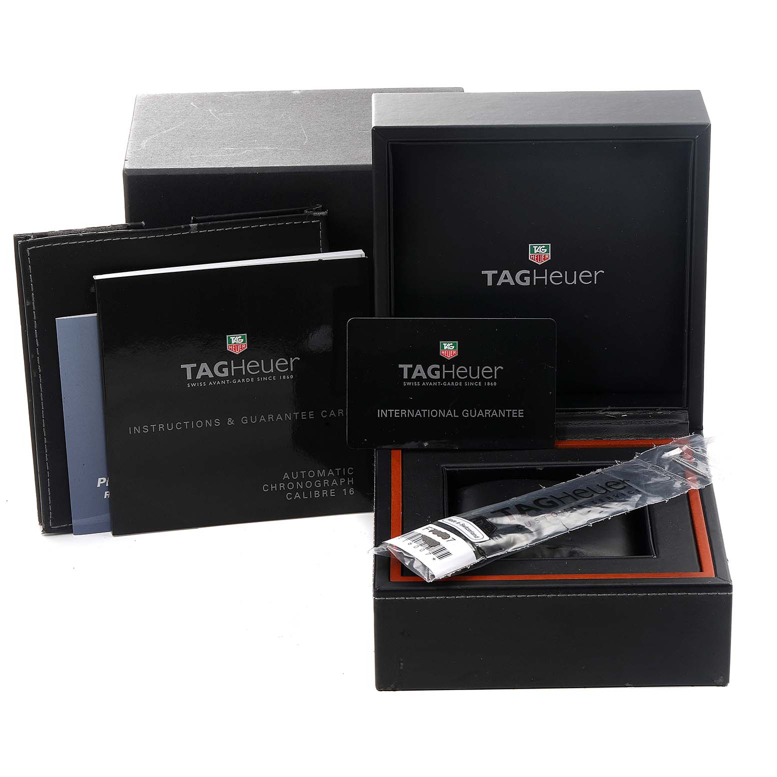 The image shows a Tag Heuer Carrera CV2014.FC6233 Men
s Stainless Steel Black Dial CV2014.FC6233 Men
s Stainless Steel Black Dial watch box, international guarantee card, instruction booklet, and a protective sleeve.