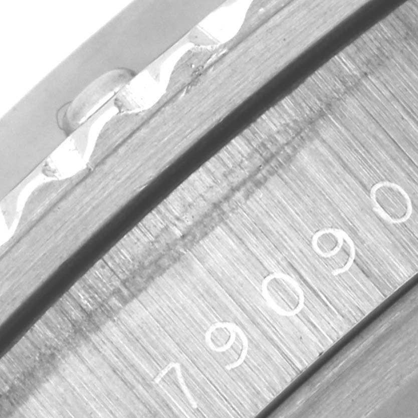 The image shows a close-up of the Tudor Submariner 79090 Men's Stainless Steel Blue Dial 79090 Men's Stainless Steel Blue Dial's side case and bezel with engraved numbers.