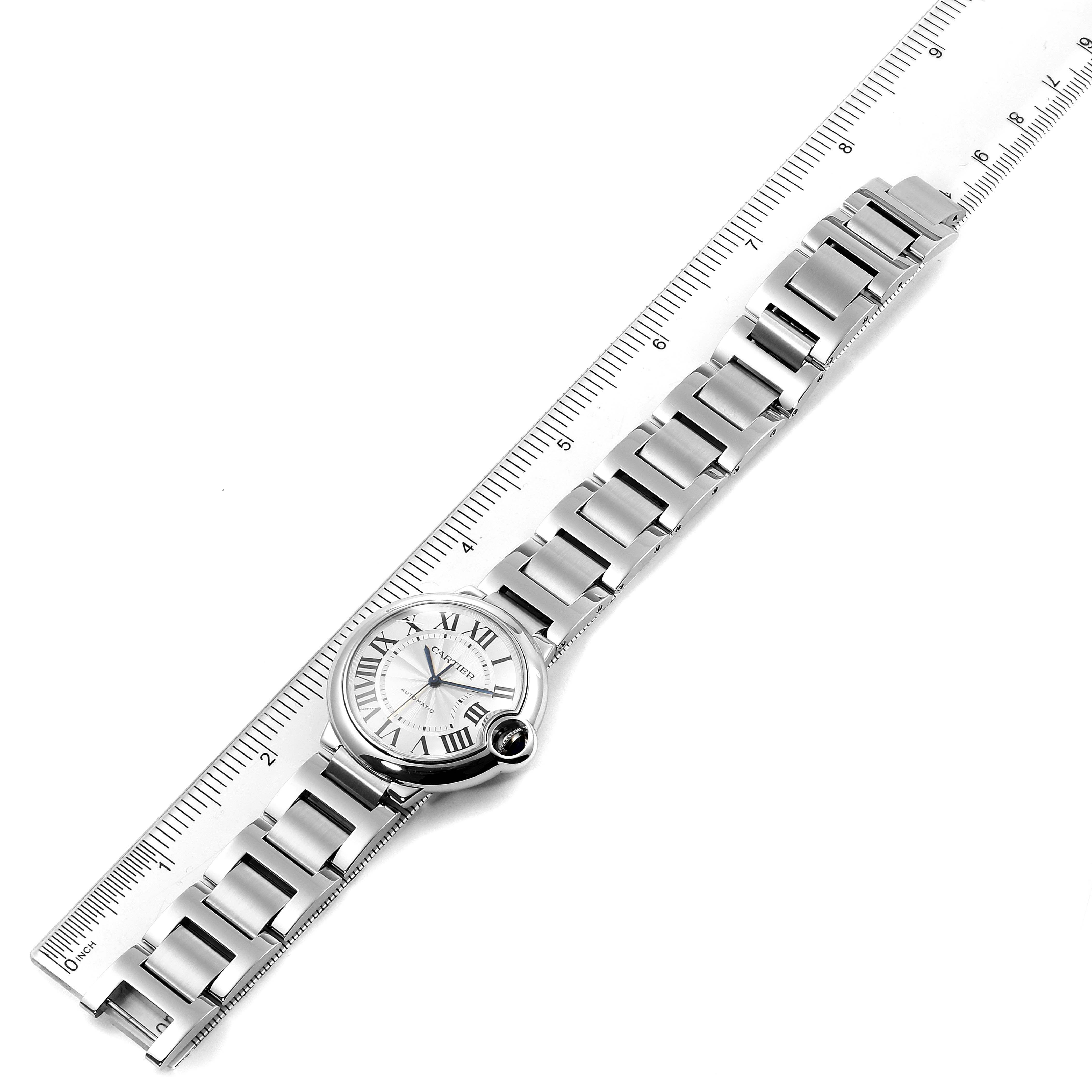 The image shows a top-down view of the Cartier Ballon Bleu W6920046 Women's Stainless Steel Silver Dial W6920046 Women's Stainless Steel Silver Dial watch along with a ruler for size reference.