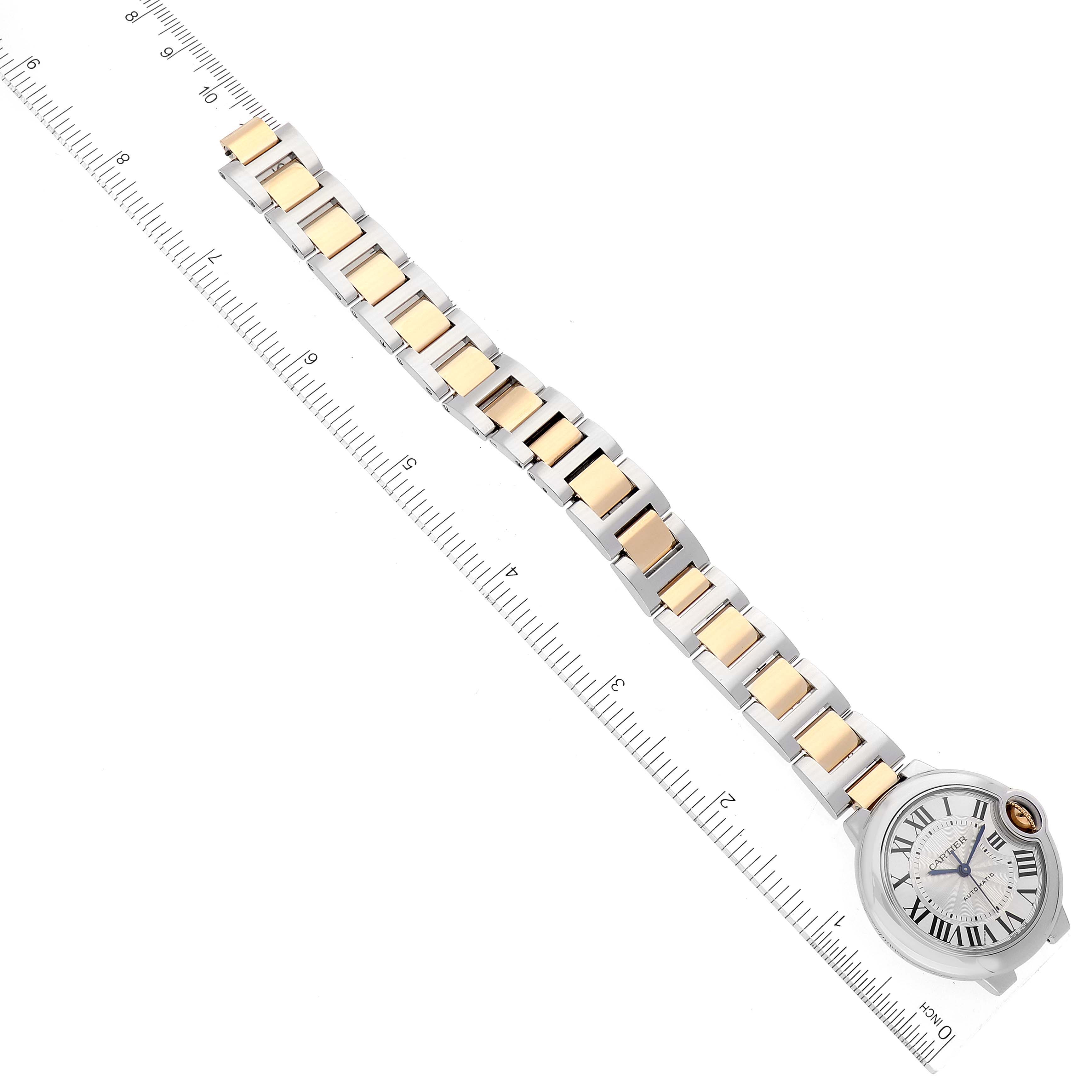 The image shows the full face and bracelet of a Cartier Ballon Bleu W2BB0029 Women
s Steel and Gold (two tone) Silver Dial W2BB0029 Women
s Steel and Gold (two tone) Silver Dial watch at a top-down angle against a ruler.