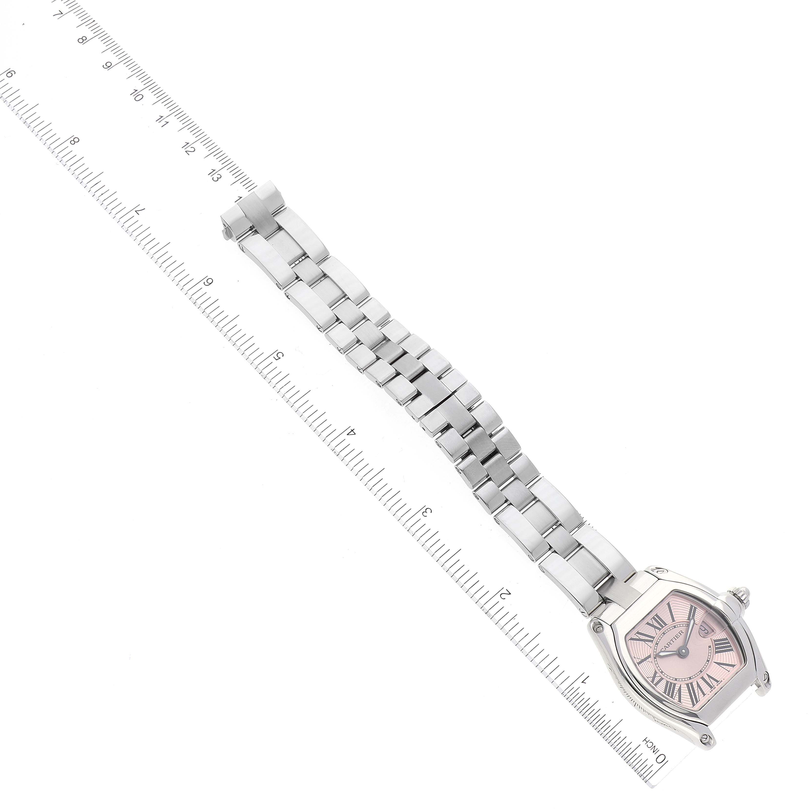 This image shows a Cartier Roadster W62017V3 Women's Stainless Steel Pink Dial W62017V3 Women's Stainless Steel Pink Dial watch displayed flat with its band extended next to a ruler.