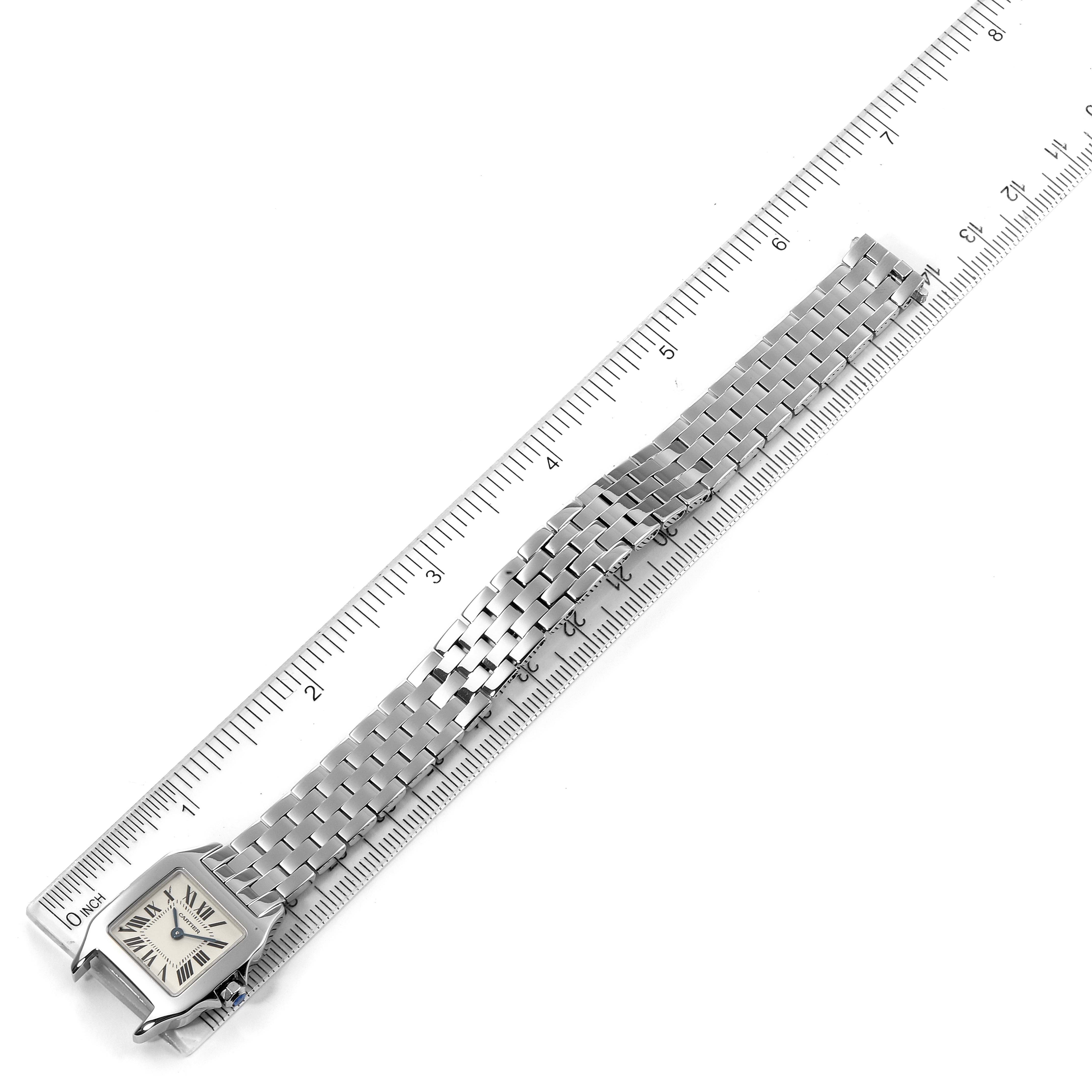 The image shows an overhead view of the Cartier Santos Demoiselle W25064Z5 Women's Stainless Steel Silver Dial W25064Z5 Women's Stainless Steel Silver Dial watch, with the watch head and full bracelet visible alongside a ruler for scale.