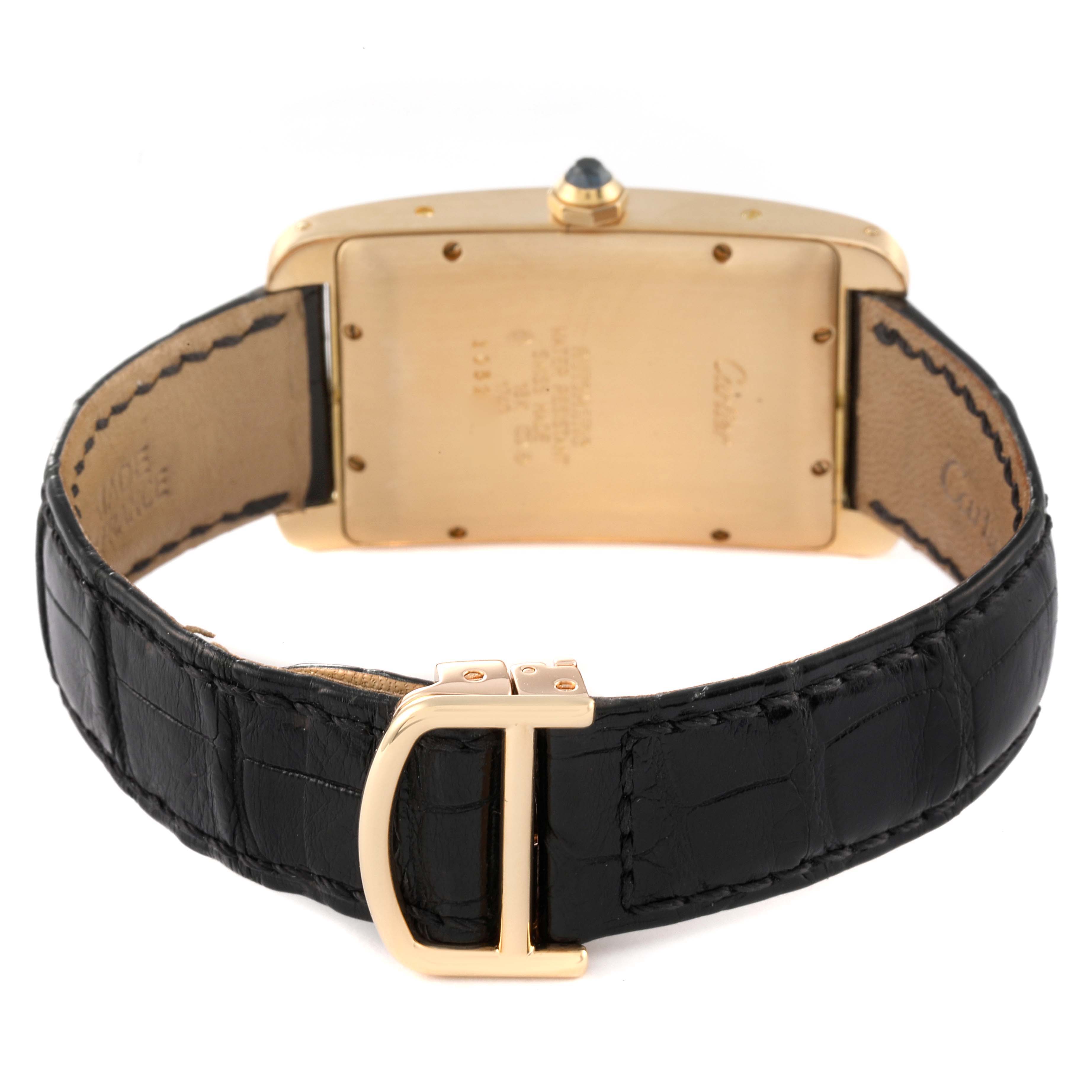 The image shows the back of the Cartier Tank Americaine W2603156 Men
s Yellow Gold Silver Dial W2603156 Men
s Yellow Gold Silver Dial watch, focusing on the strap and clasp with partial view of the case back.