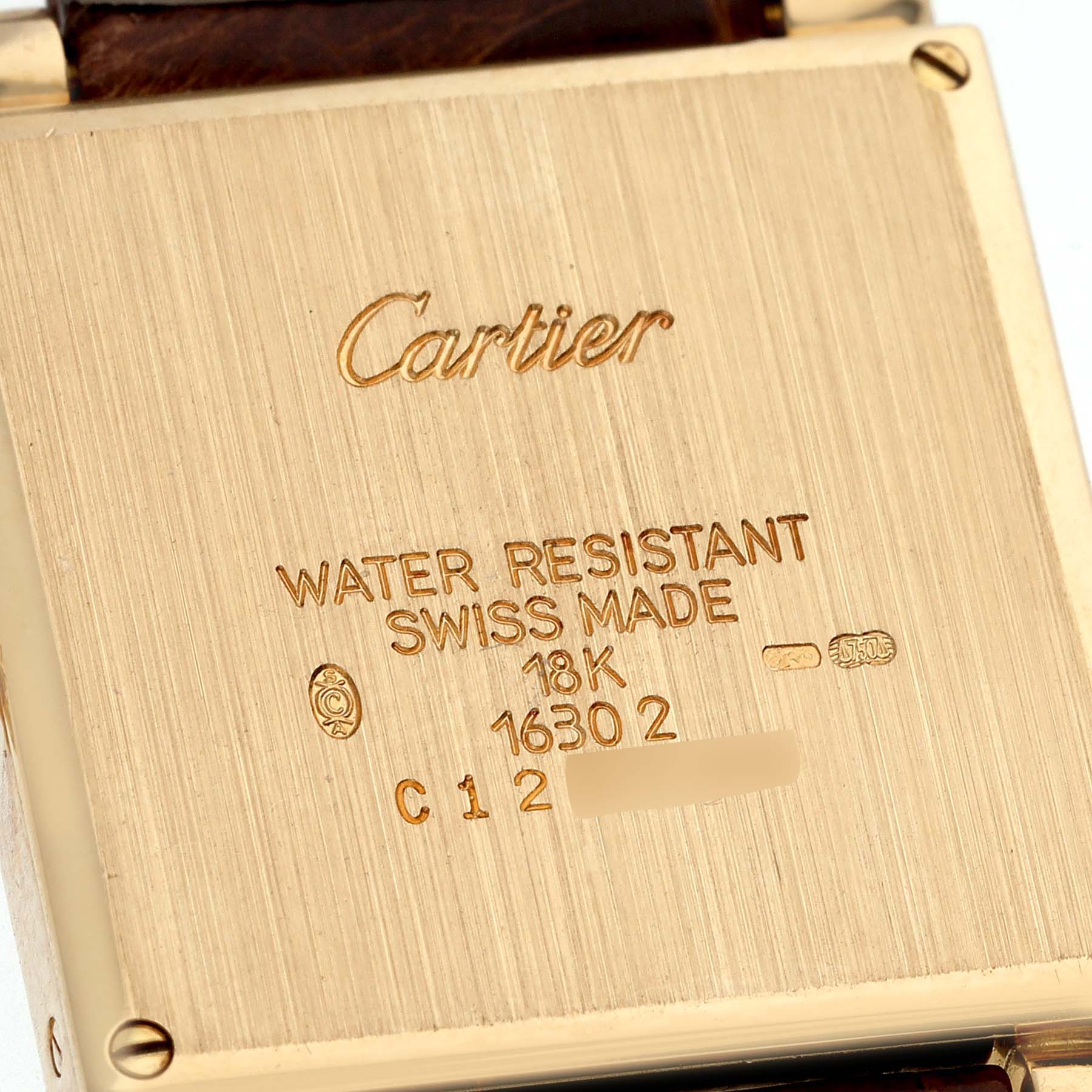 The image shows the back of a Cartier Tank Obus W1512256 Women
s Yellow Gold Silver Dial W1512256 Women
s Yellow Gold Silver Dial watch, featuring engravings of the brand, model, and material details.