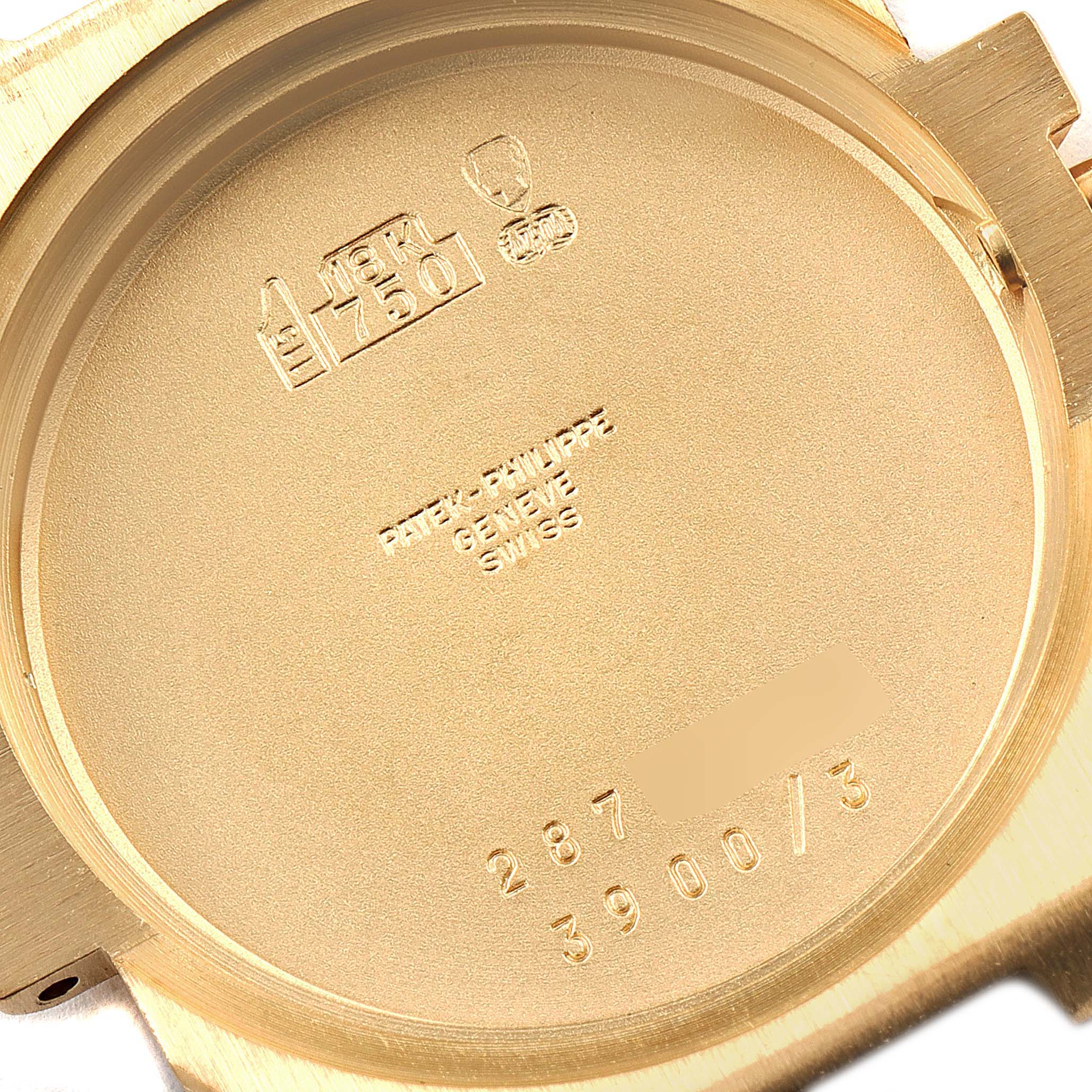 This image shows the inside of the case back of a Patek Philippe Nautilus 3900/003 Women's Yellow Gold Champagne Dial 3900/003 Women's Yellow Gold Champagne Dial watch, displaying hallmarks and engravings.