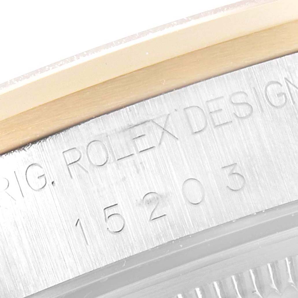 The image shows a close-up of the side engraving of a Rolex Date 15203 Men's Steel and Gold (two tone) White Dial 15203 Men's Steel and Gold (two tone) White Dial model watch with visible serial numbers.