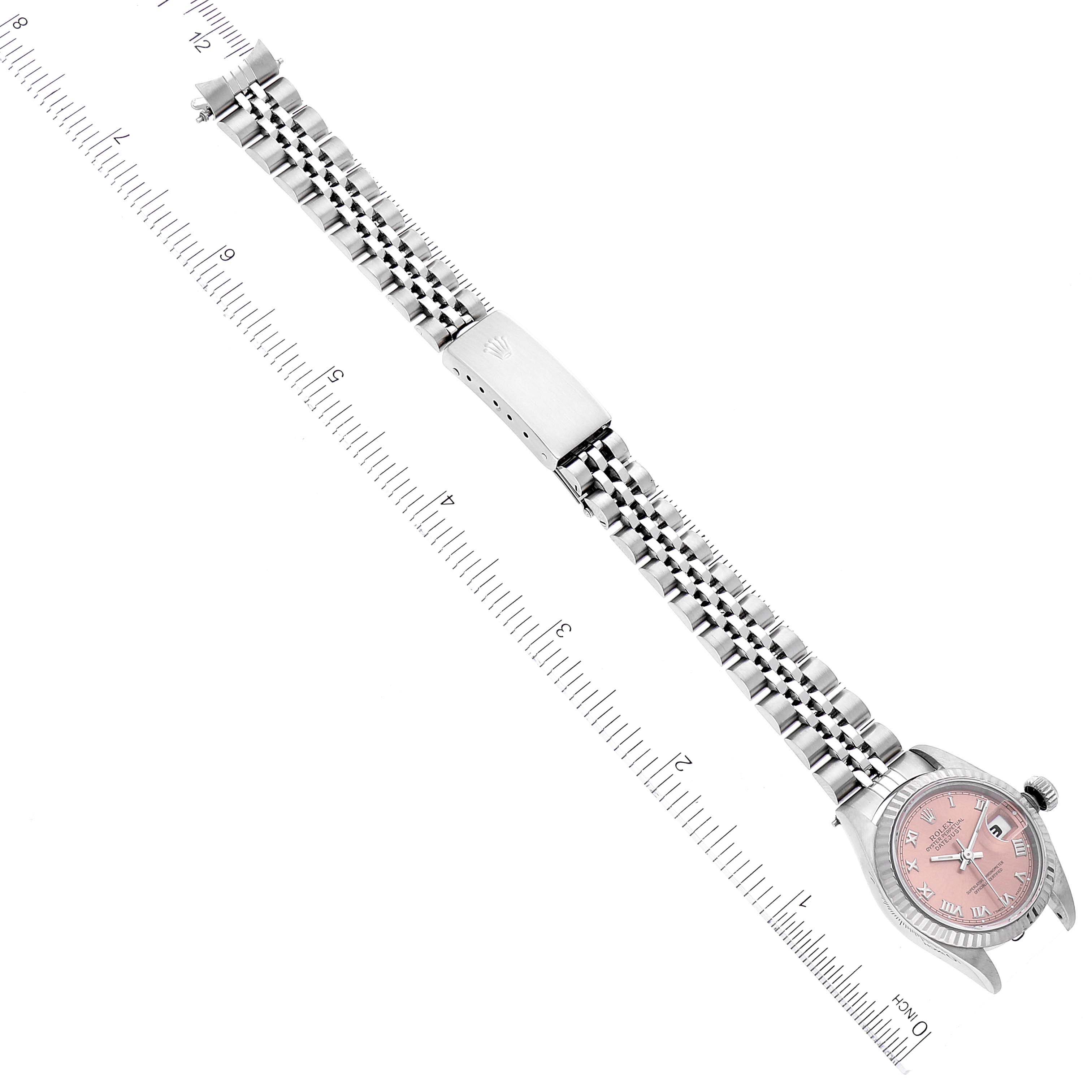 The image showcases the entire Rolex Datejust 69174 Women's Stainless Steel Pink Dial 69174 Women's Stainless Steel Pink Dial watch, including its dial, bezel, crown, and bracelet, aligned next to a ruler.