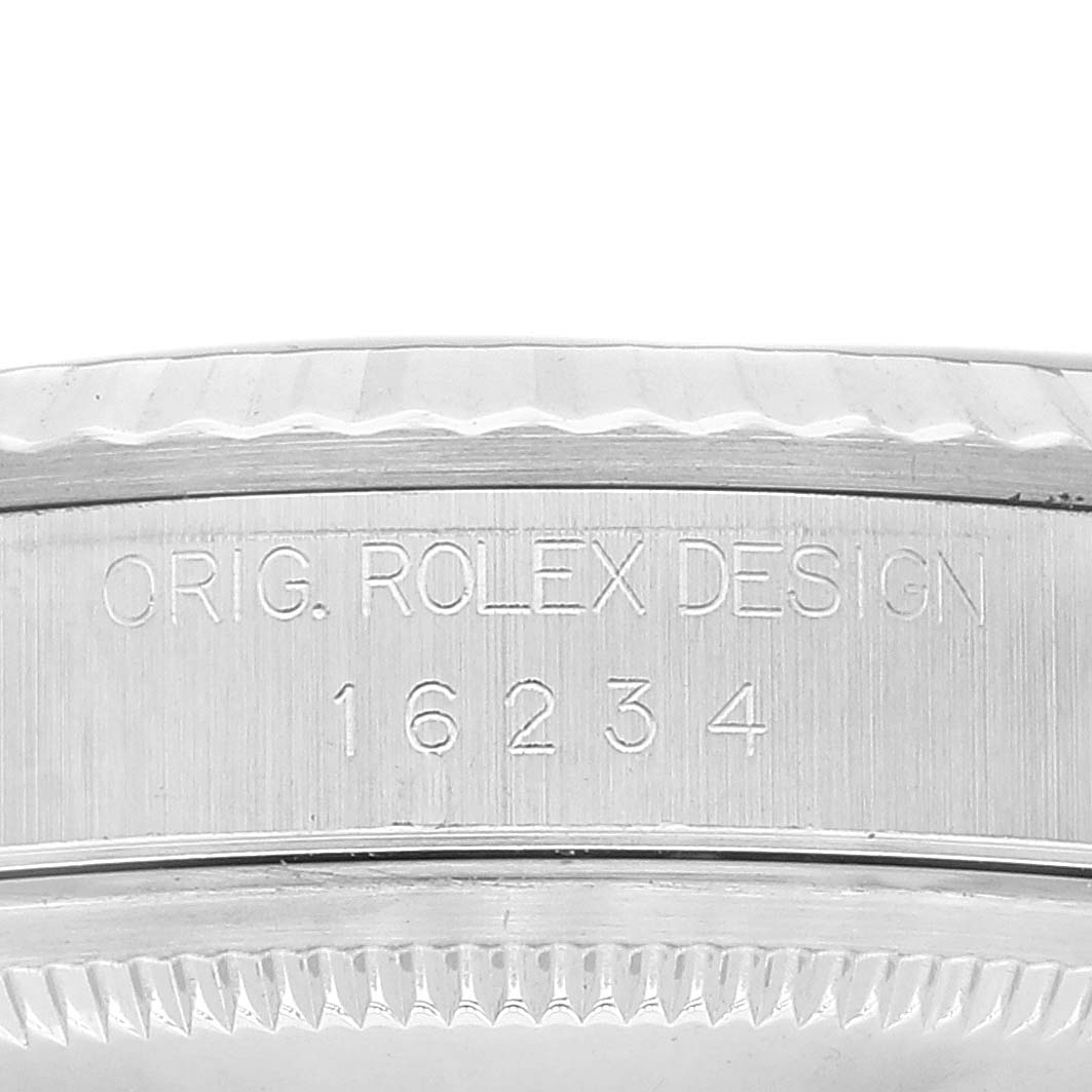 The image shows a close-up of the side of the Rolex Datejust 16234 Men's Stainless Steel Blue Dial 16234 Men's Stainless Steel Blue Dial model, focusing on the engraved serial number and design inscription.