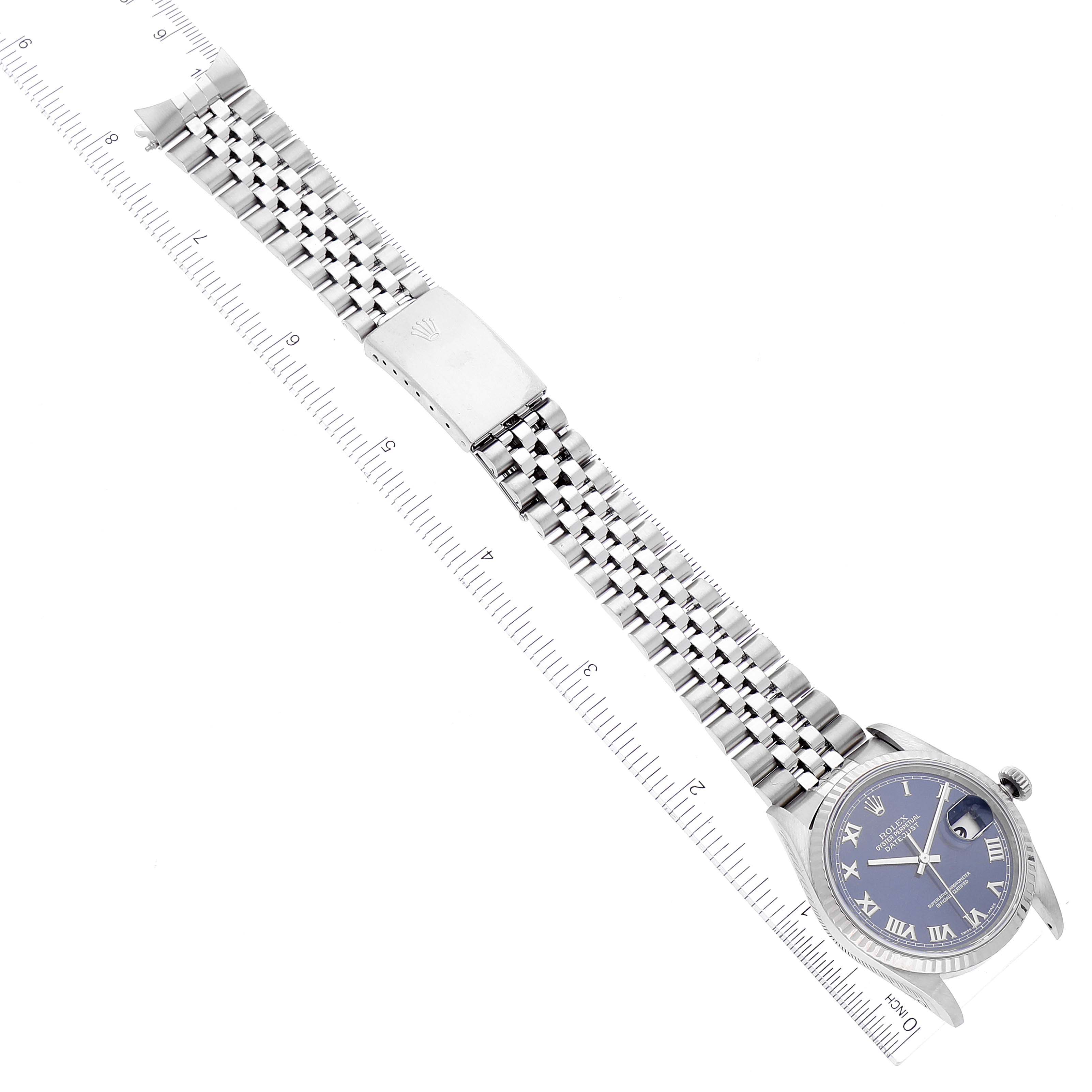 The image shows the Rolex Datejust 16234 Men's Stainless Steel Blue Dial 16234 Men's Stainless Steel Blue Dial watch from an angled top view, showcasing the dial, bracelet, and clasp with a ruler for scale.