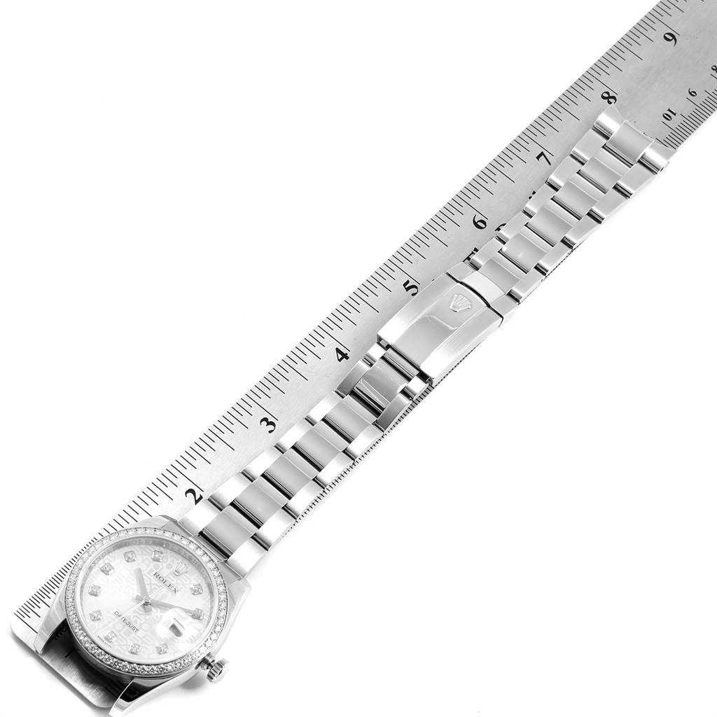 The image shows a top view of a Rolex Datejust 116244 Men's Stainless Steel Silver Dial 116244 Men's Stainless Steel Silver Dial watch, displaying the watch face, bracelet, and clasp next to a ruler.