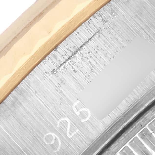 The image shows a close-up of the Rolex Datejust 69173 Women's Steel and Gold (two tone) Champagne Dial 69173 Women's Steel and Gold (two tone) Champagne Dial model's metal bezel and edge with part of the engraved serial number.