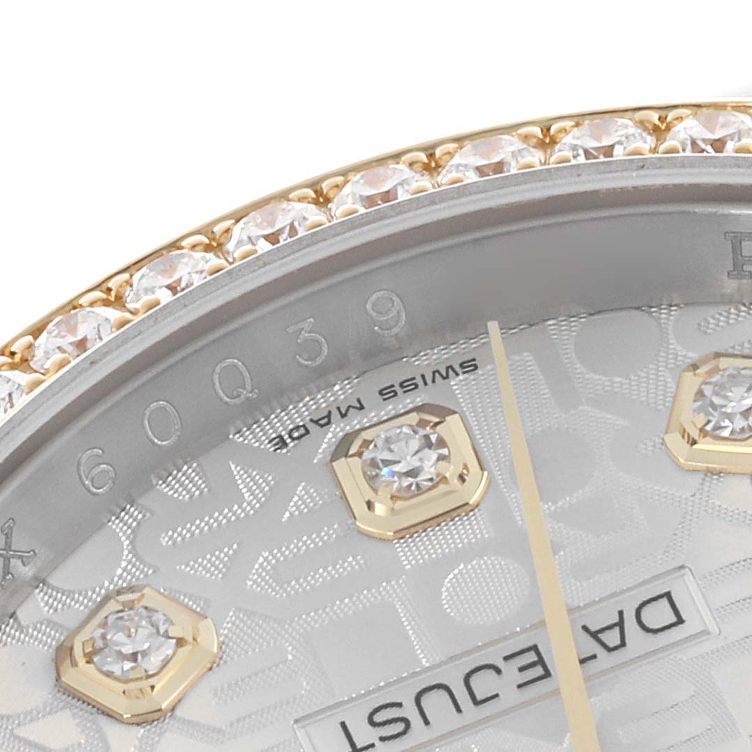 The image shows a close-up of a Rolex Datejust 116243 Men
s Steel and Gold (two tone) Silver Dial 116243 Men
s Steel and Gold (two tone) Silver Dial watch, featuring part of the bezel with diamonds and the dial with markers.