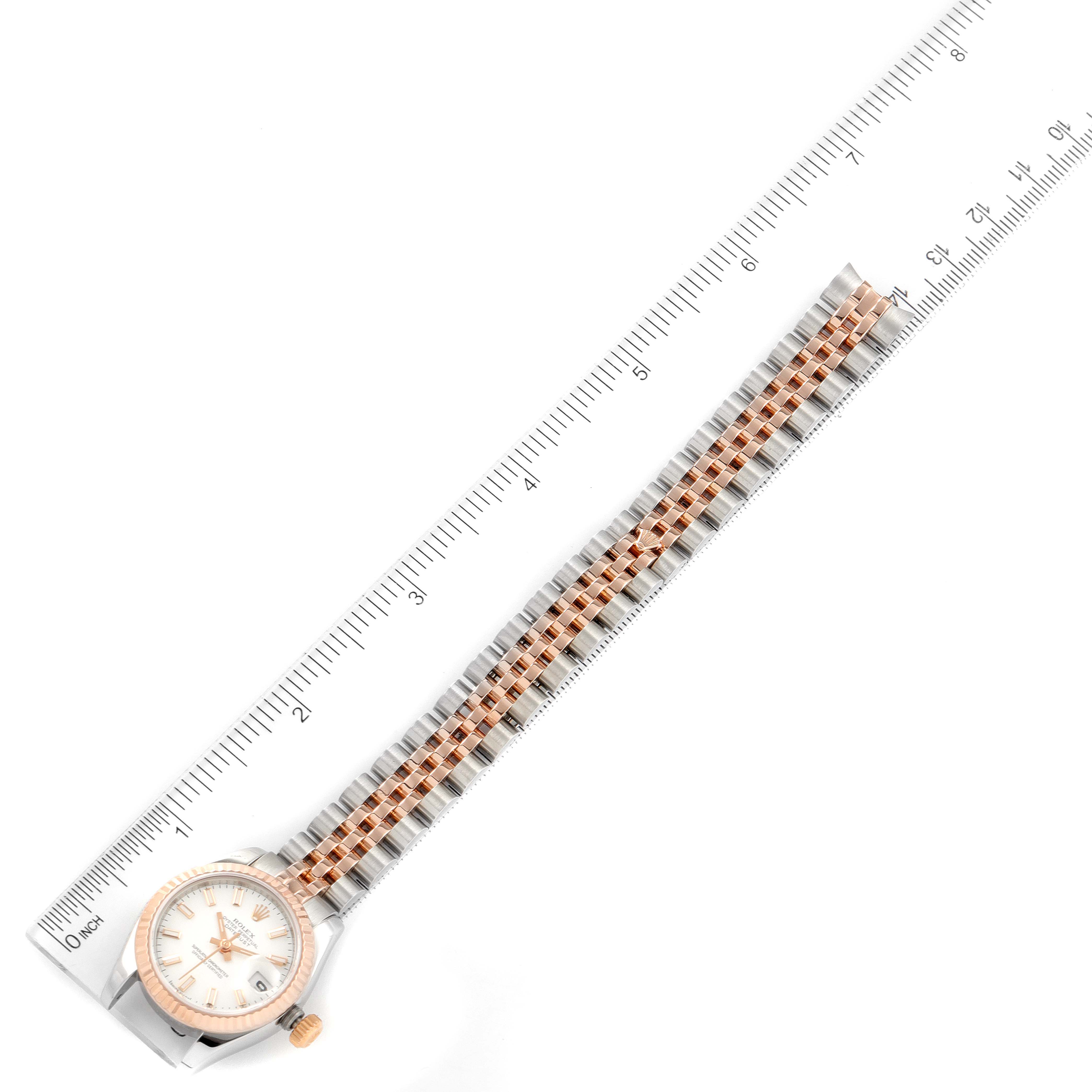 The image shows an overhead view of a Rolex Datejust 179171 Women's Steel and Gold (two tone) White Dial 179171 Women's Steel and Gold (two tone) White Dial watch, focusing on the face and the full length of the metal bracelet with a ruler.