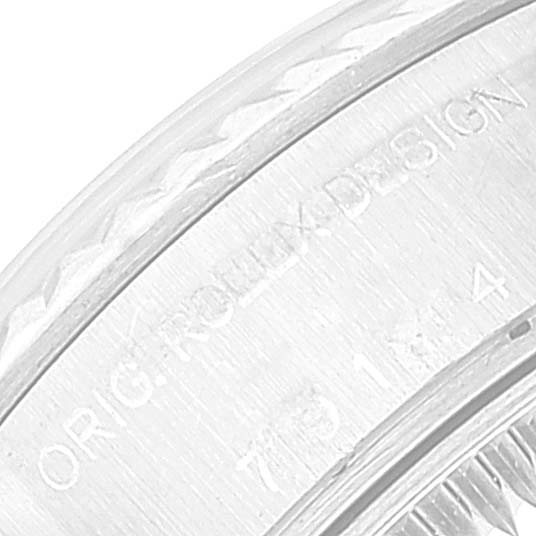 The image shows a close-up of the engraved bezel and part of the case of the Rolex Datejust 79174 Women's Stainless Steel Blue Dial 79174 Women's Stainless Steel Blue Dial watch.