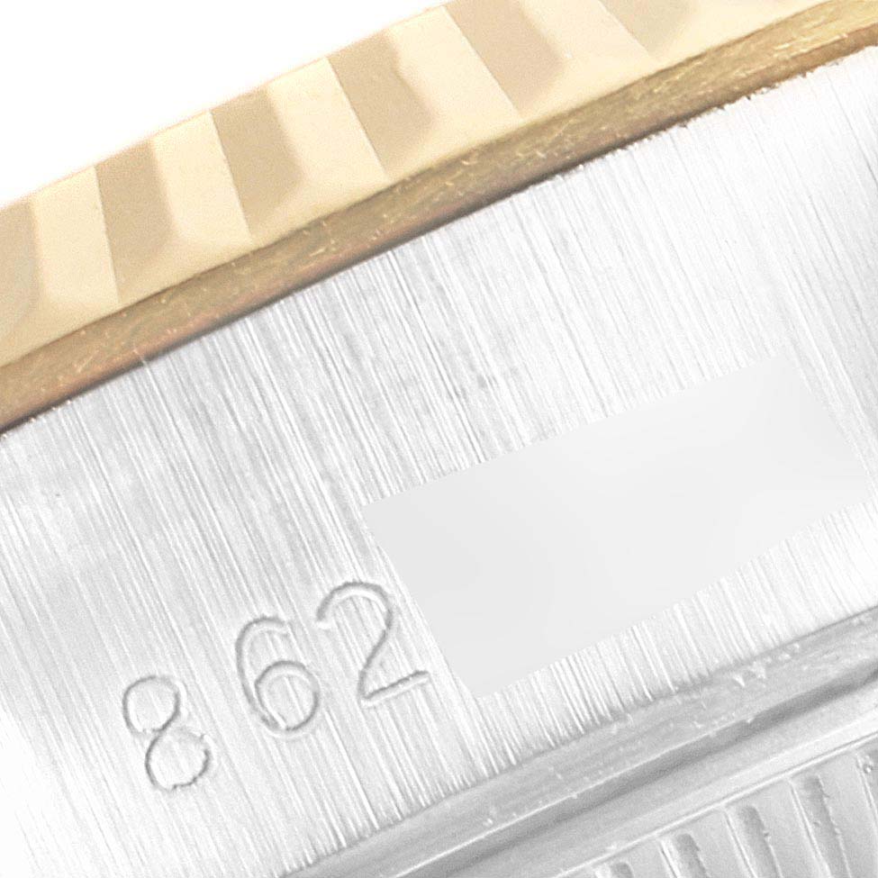 This close-up image shows part of the fluted bezel and the case of a Rolex Datejust 69173 Women's Steel and Gold (two tone) Champagne Dial 69173 Women's Steel and Gold (two tone) Champagne Dial watch with some visible engraving.