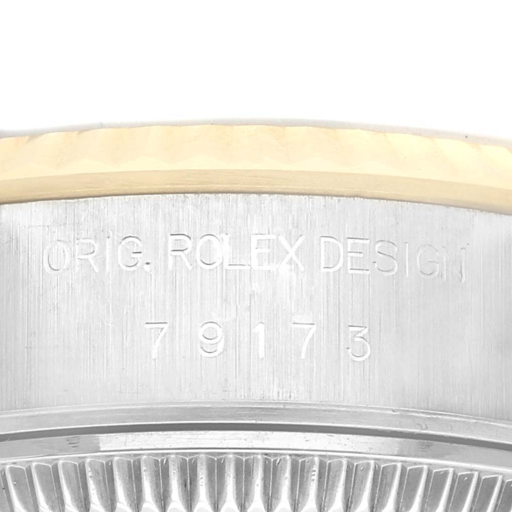 The image shows a close-up of the side of a Rolex Datejust 79173 Women's Steel and Gold (two tone) Silver Dial 79173 Women's Steel and Gold (two tone) Silver Dial, highlighting its engraved design number and fluted bezel.