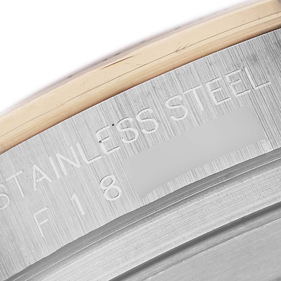 The image shows a close-up of the side of the Rolex Daytona 116523 Men
s Steel and Gold (two tone) White Dial 116523 Men
s Steel and Gold (two tone) White Dial watch case, highlighting the "STAINLESS STEEL" engraving.