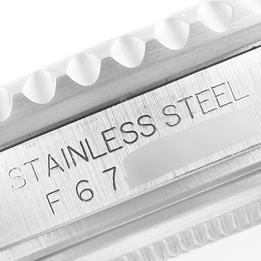 The image shows a close-up of the side of a Rolex GMT-Master 16710 Men
s Stainless Steel Black Dial 16710 Men
s Stainless Steel Black Dial watch, featuring the "STAINLESS STEEL" engraving and part of the bezel.