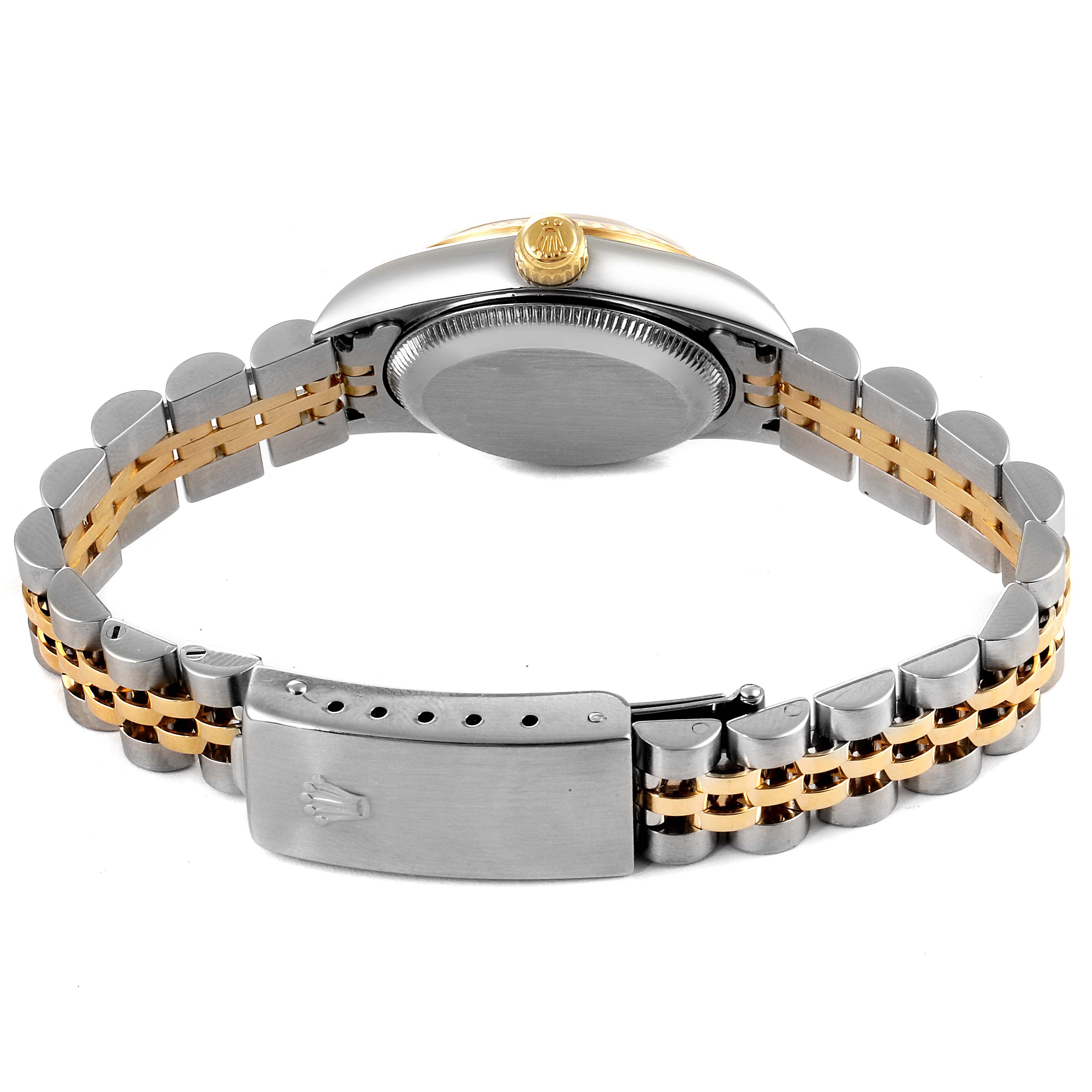 The image shows the back view of a Rolex Oyster Perpetual 76193 Women
s Steel and Gold (two tone) Champagne Dial 76193 Women
s Steel and Gold (two tone) Champagne Dial watch with its bracelet and clasp visible.
