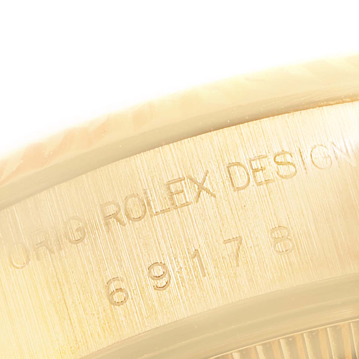 This image shows an up-close view of the side of the case of a Rolex President 69178 Women
s Yellow Gold Champagne Dial 69178 Women
s Yellow Gold Champagne Dial watch, highlighting the "ORIG ROLEX DESIGN" engraving.
